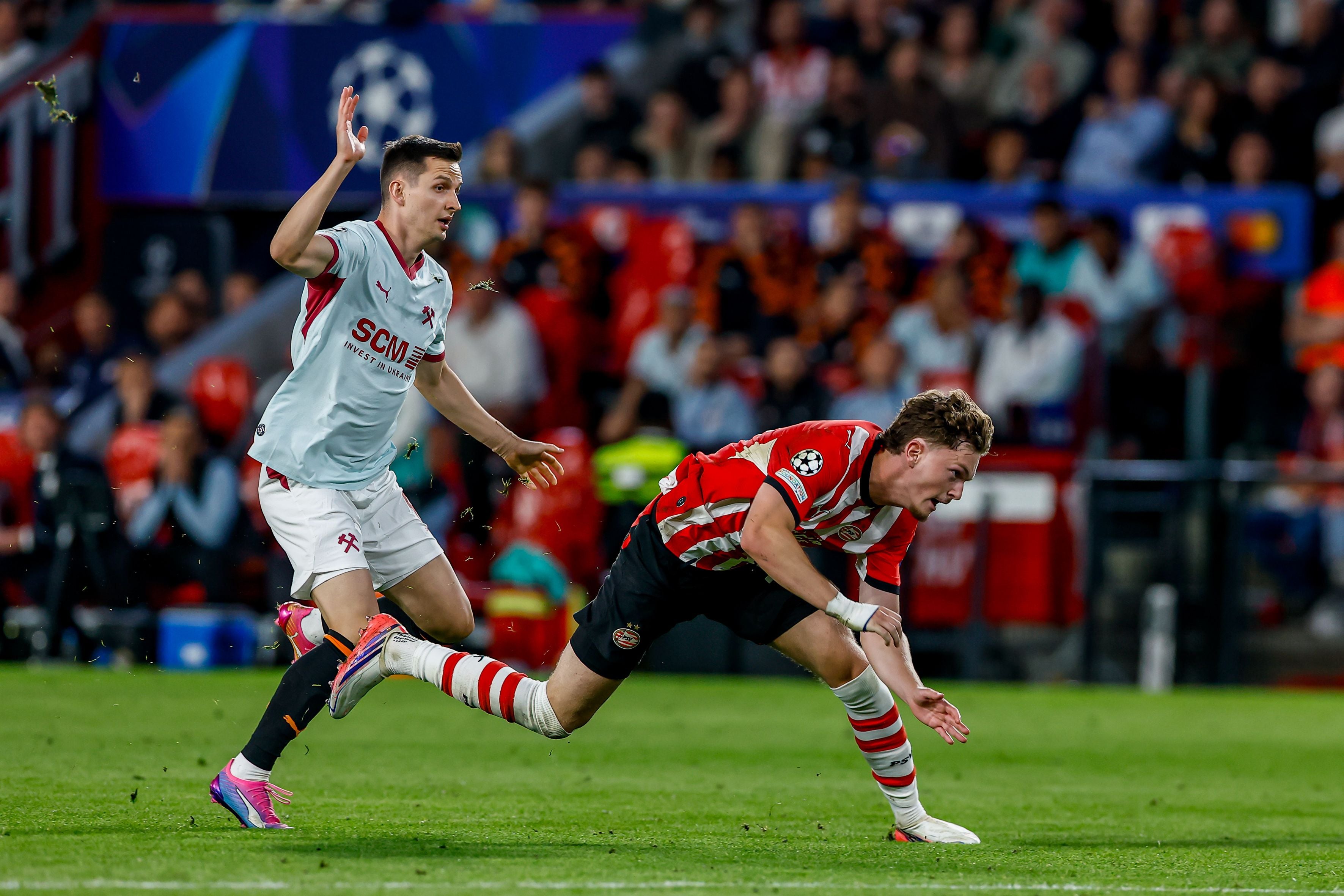Ein Spieler von PSV Eindhoven fällt beim Zweikampf mit einem Spieler von Shakhtar Donetsk.