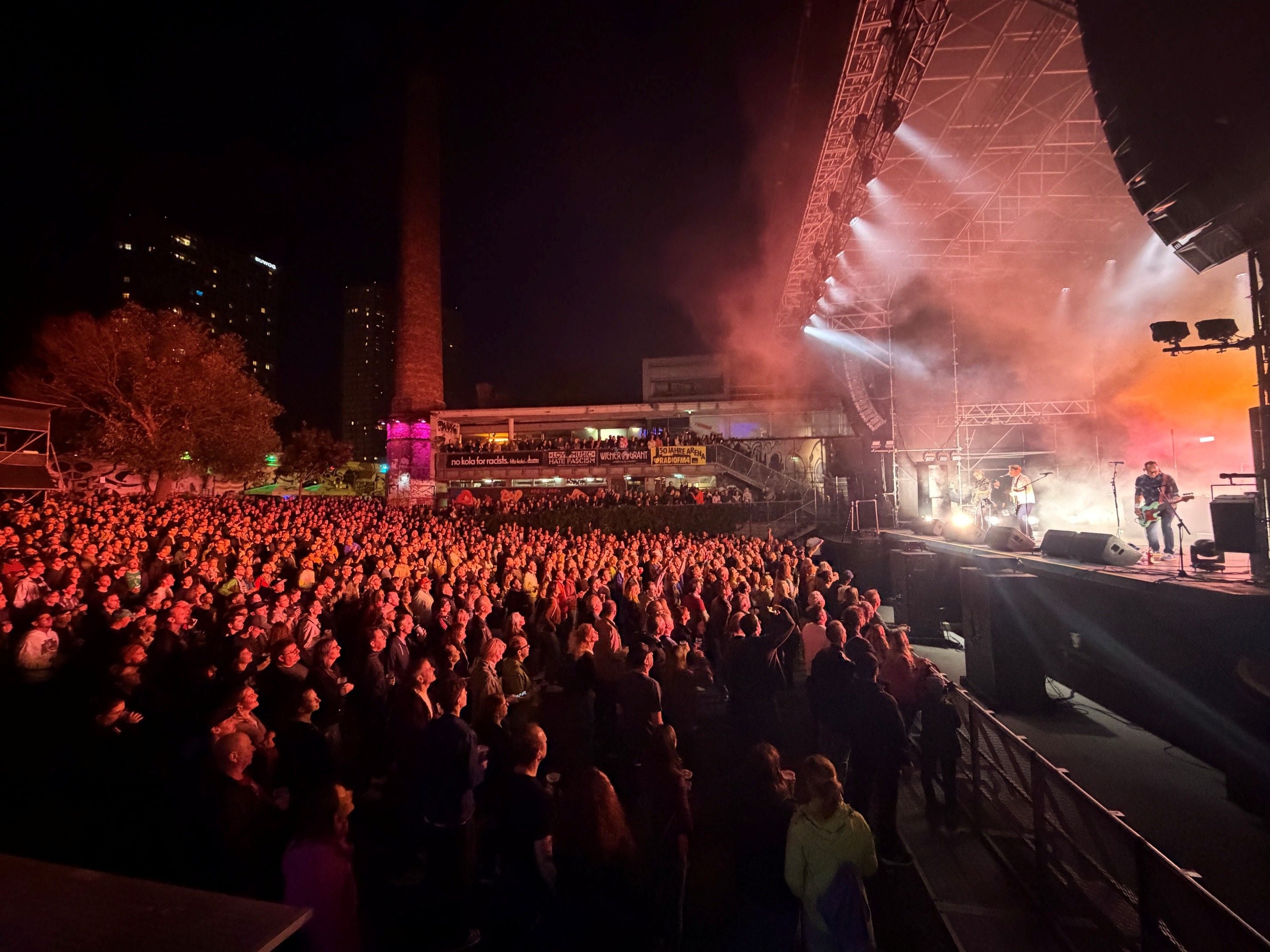 Große Menschenmenge vor einer Bühne bei einem Konzert im Freien bei Nacht.