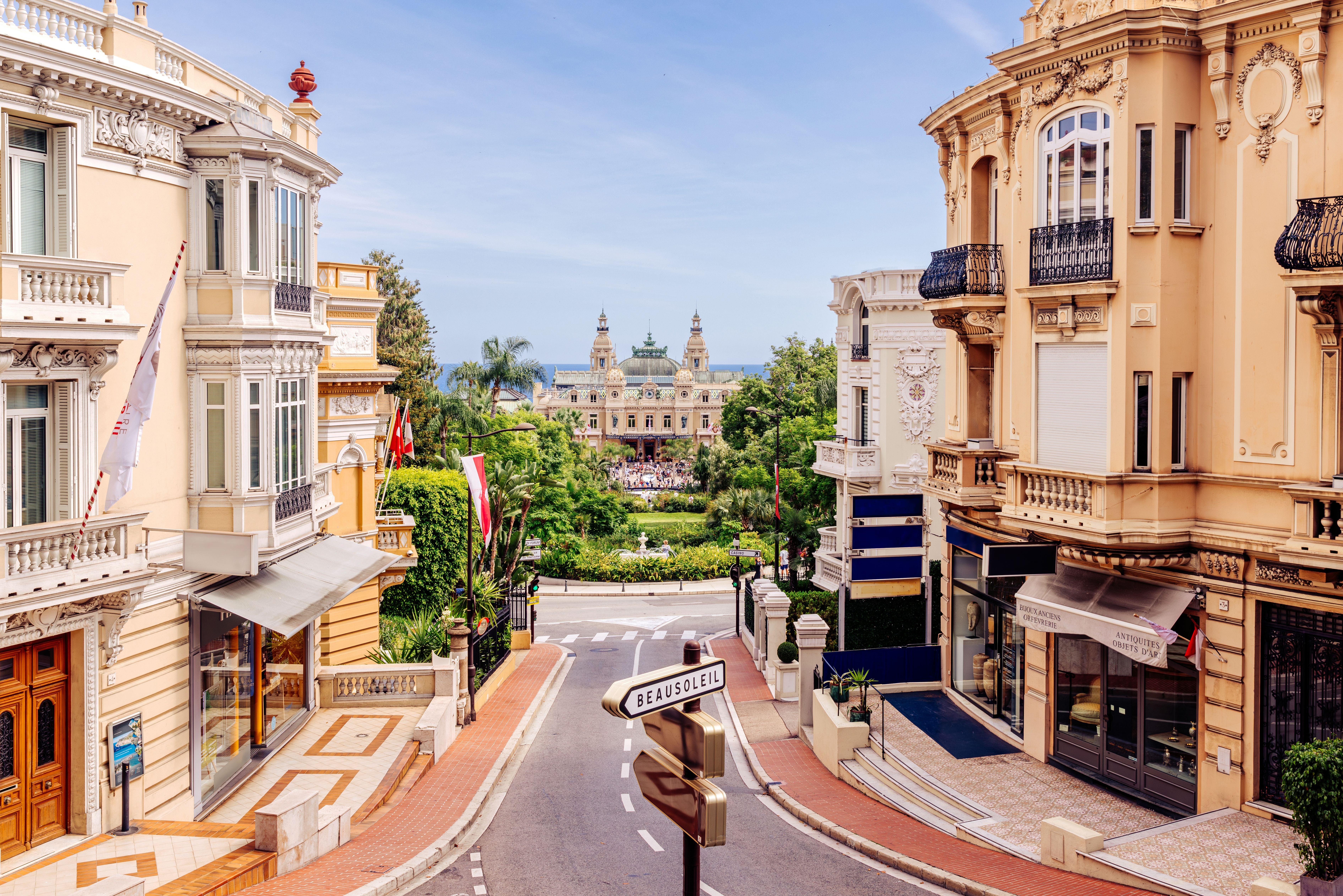 Straße mit eleganten Gebäuden führt zum berühmten Casino von Monte Carlo in Monaco.