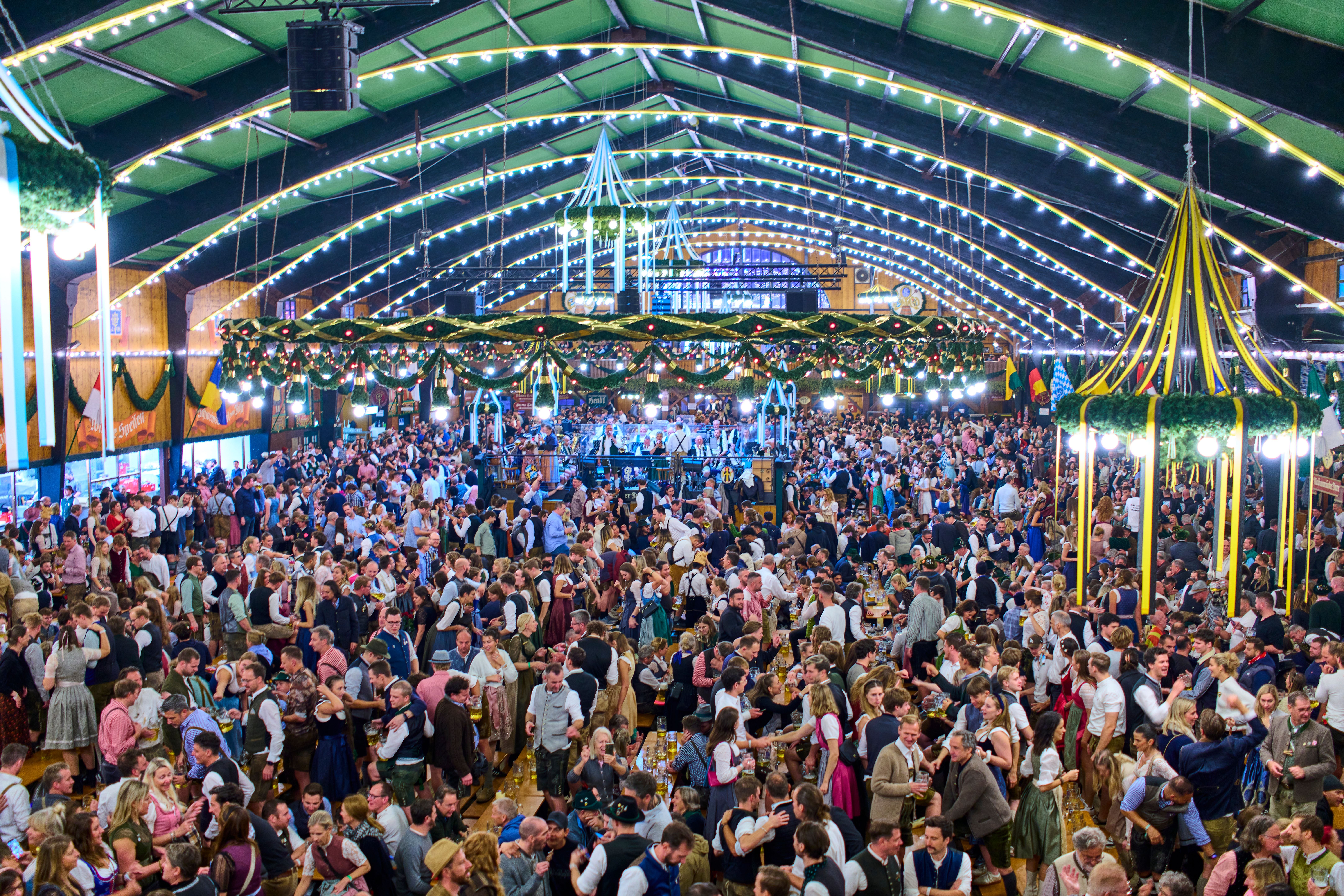Große Menschenmenge feiert in einem festlich geschmückten Bierzelt beim Oktoberfest in München.