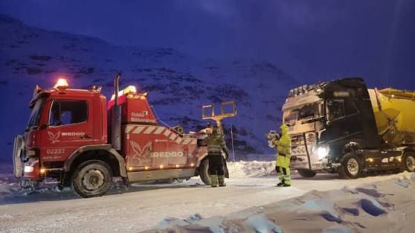 Ein Abschleppwagen hilft einem LKW bei winterlichen Straßenverhältnissen im Schnee.