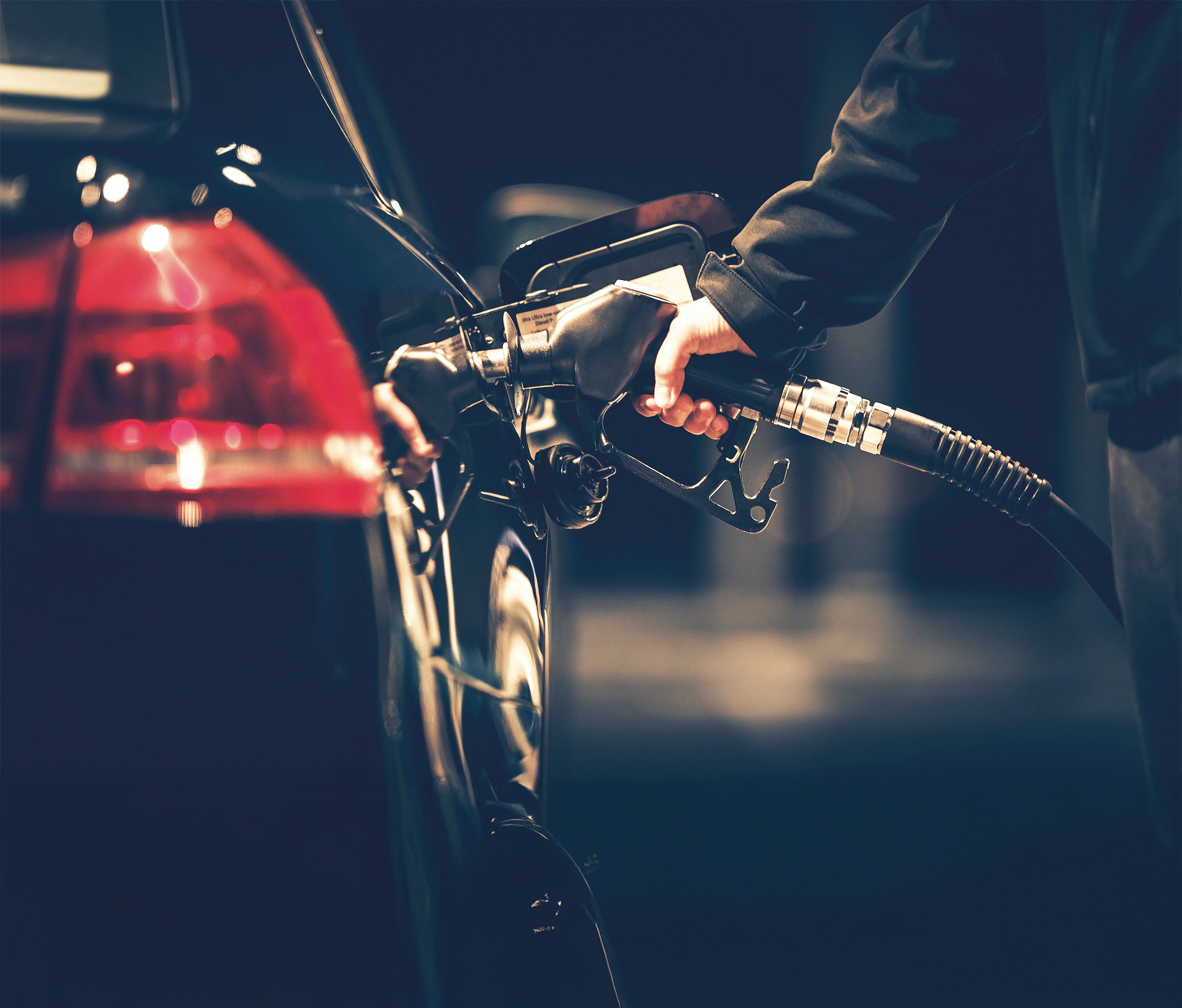 Eine Person tankt ein Auto an einer Zapfsäule an einer Tankstelle.