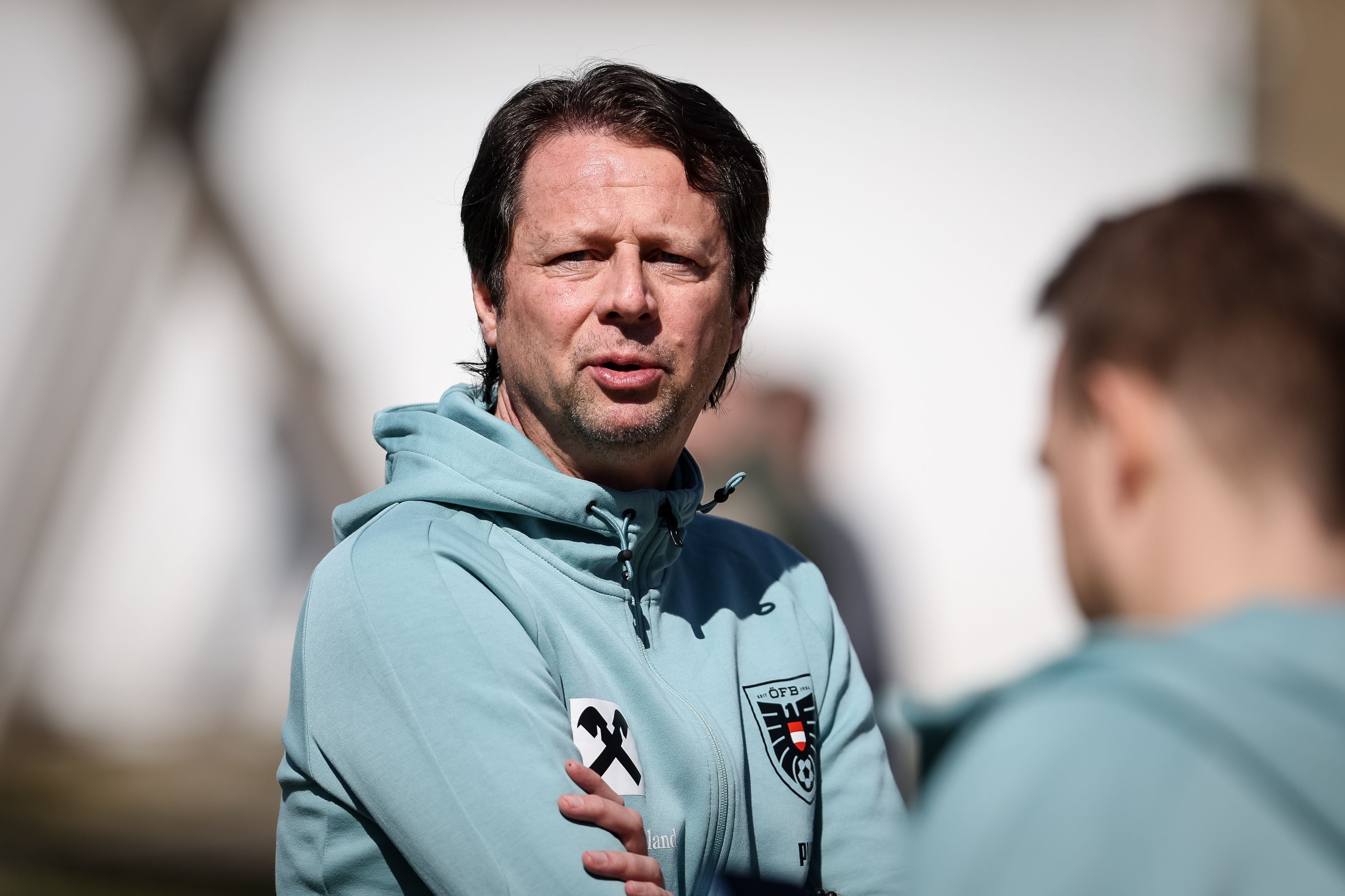 Ein Mann im OEFB-Trainingsanzug steht draußen und blickt in die Kamera.