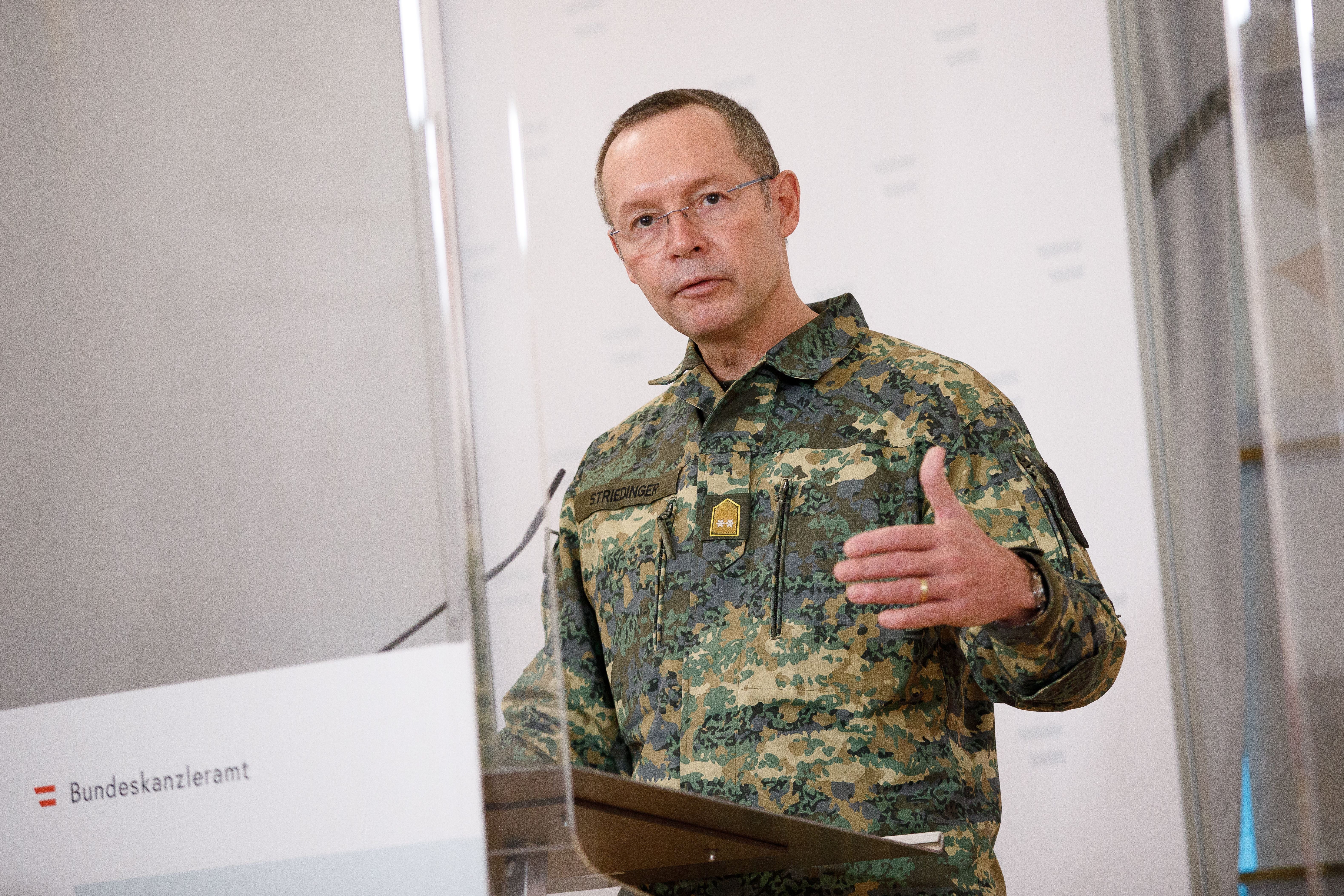 Ein Militär in Tarnuniform spricht bei einer Pressekonferenz im Bundeskanzleramt.