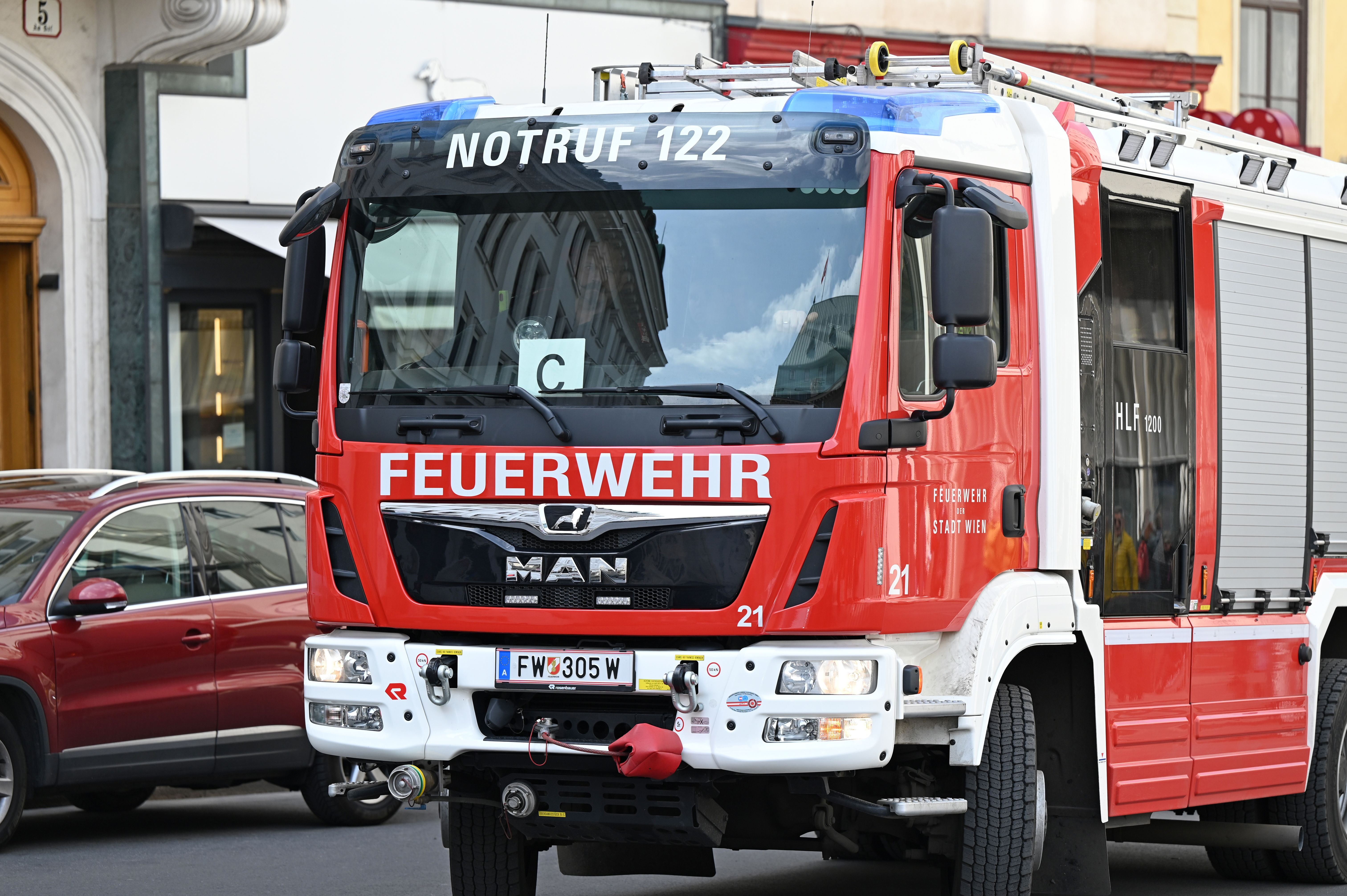Rotes Feuerwehrfahrzeug der Stadt Wien steht auf einer Straße.