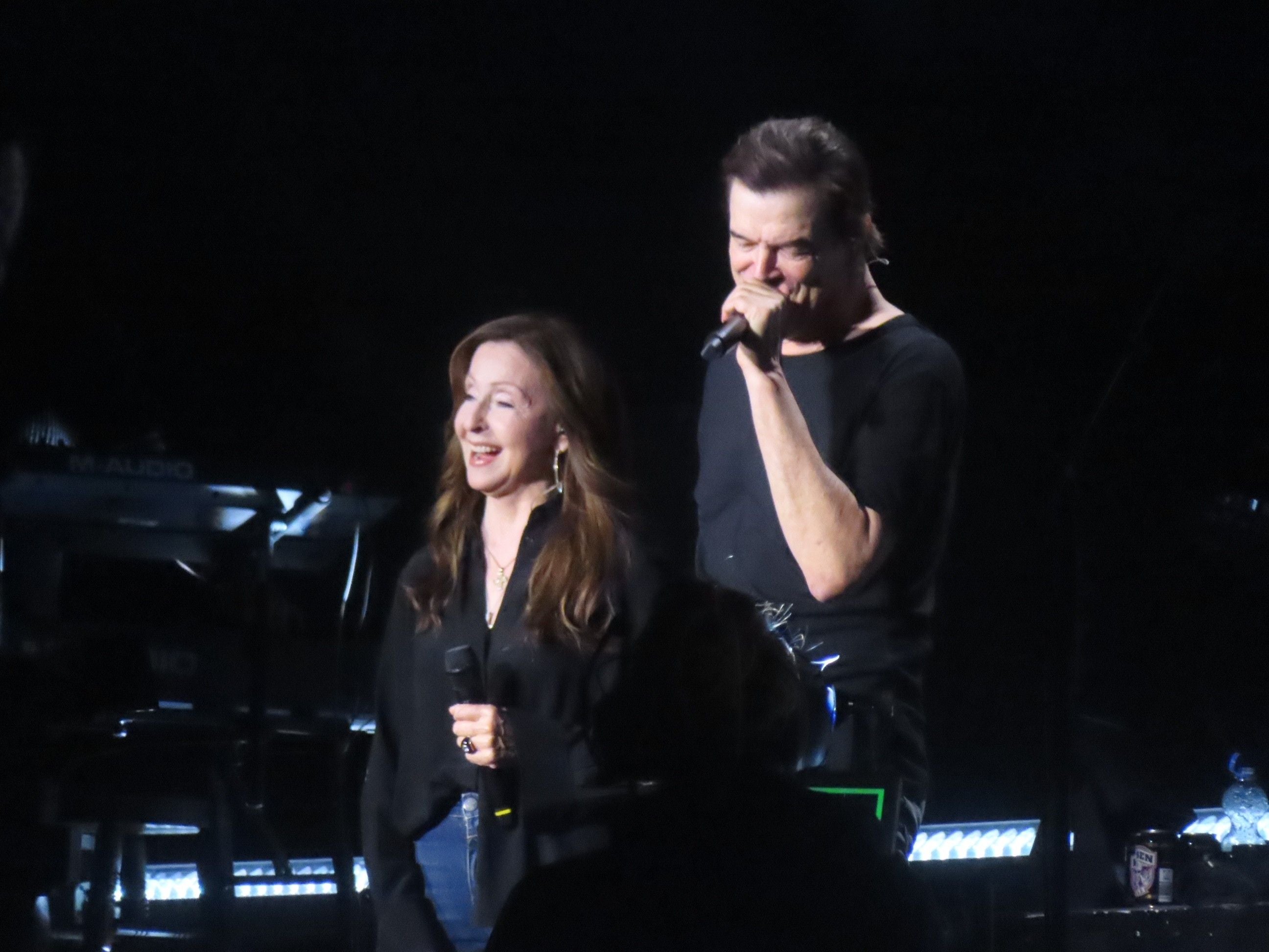 Vicky Leandros und ein Mann singen zusammen auf der Bühne bei einem Konzert.