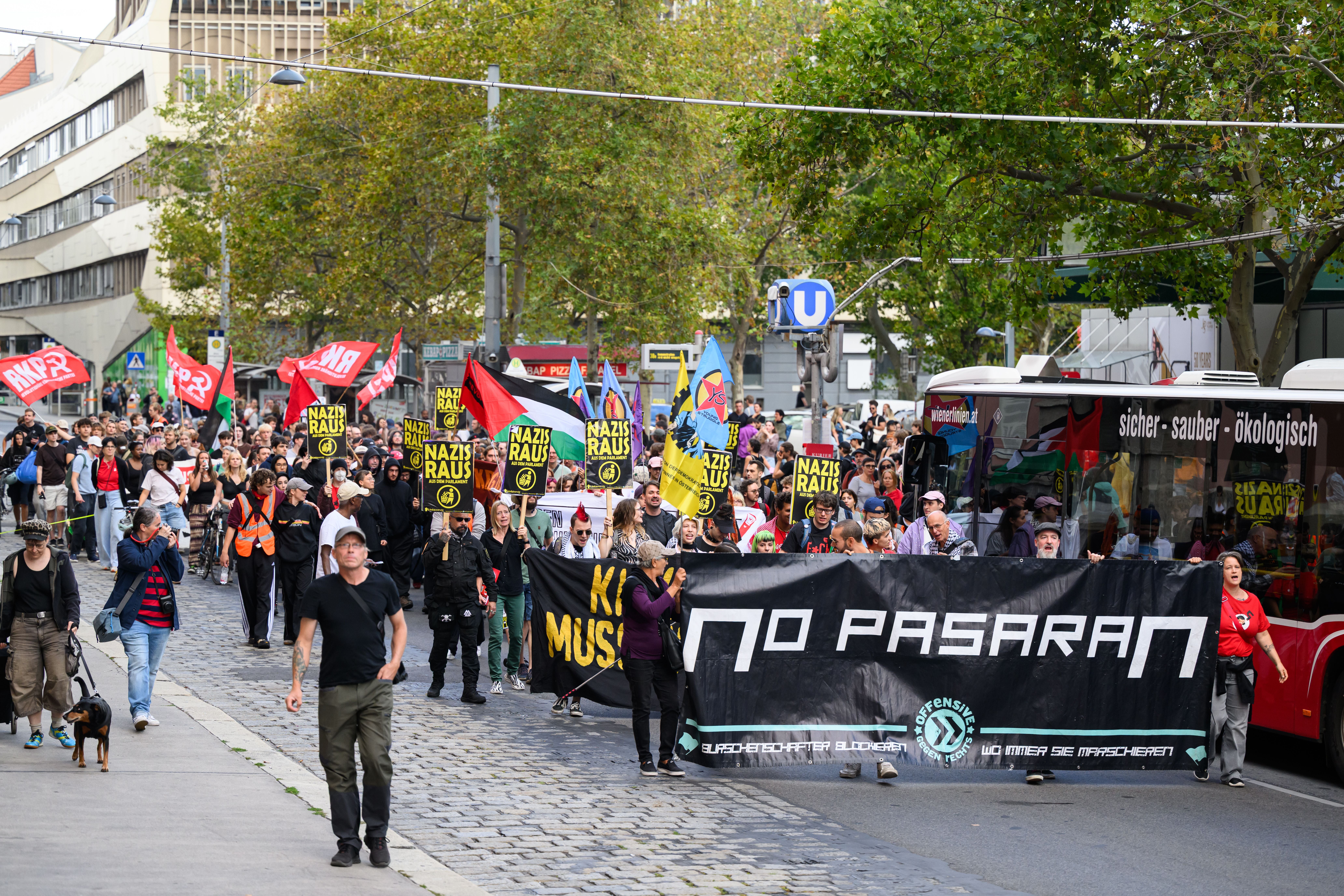 Menschen demonstrieren mit Bannern und Schildern, auf denen "Nazis raus" und "No Pasaran" steht.