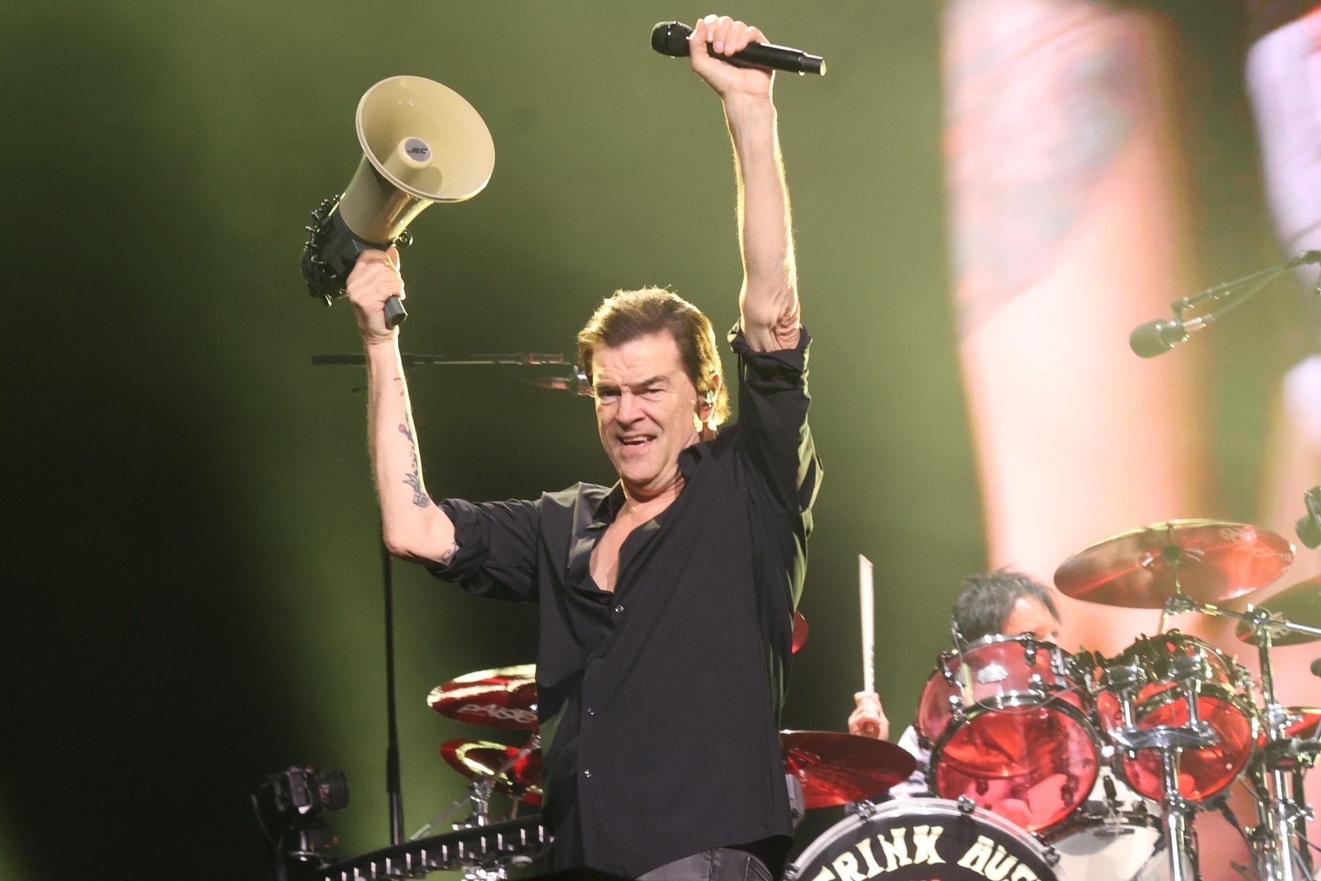 Sänger hält Megafon und Mikrofon auf der Bühne bei einem Die Toten Hosen-Konzert hoch.