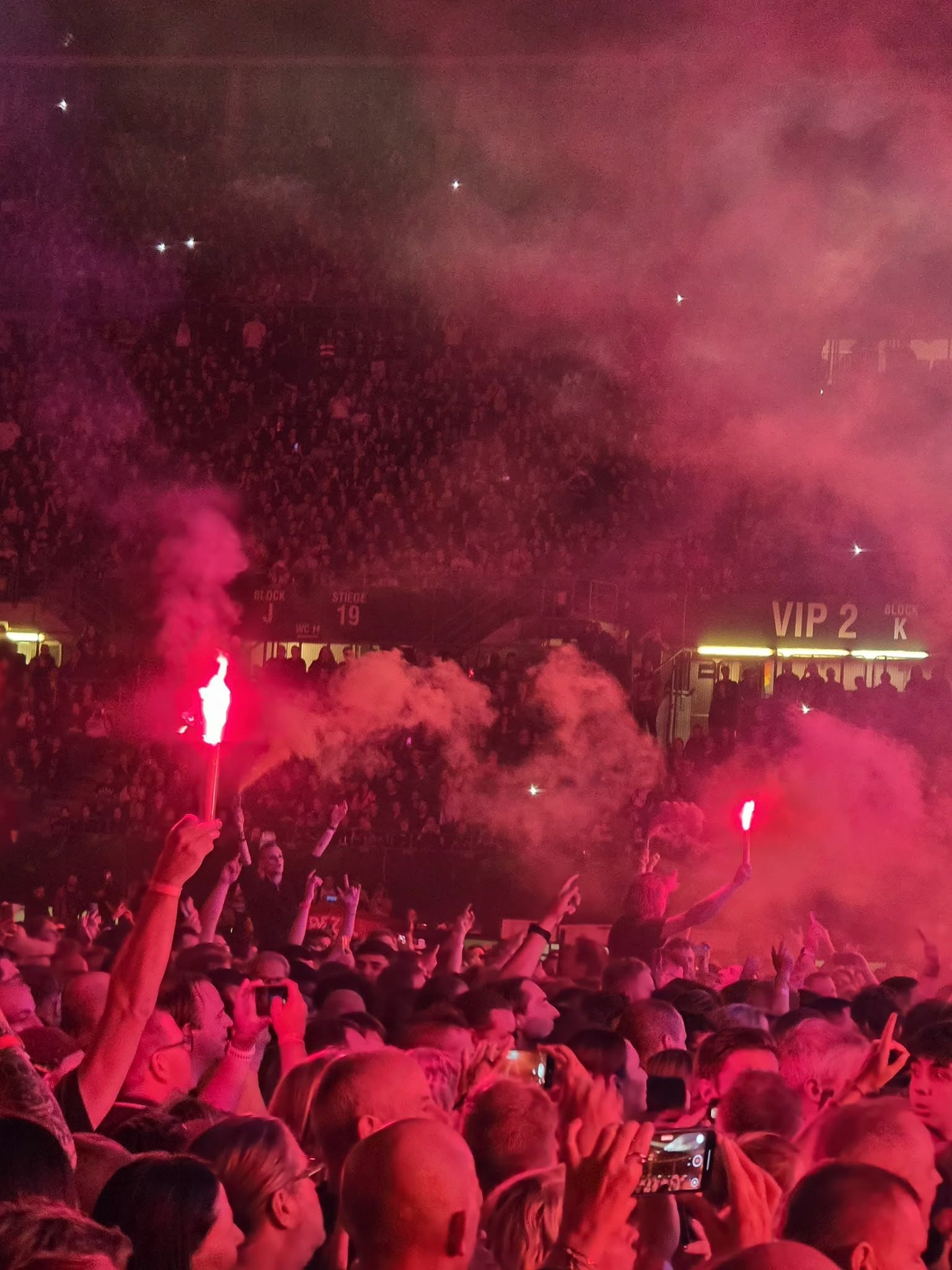 Menschenmenge beim Die Toten Hosen-Konzert mit roten Fackeln und Rauch im Ernst-Happel-Stadion.