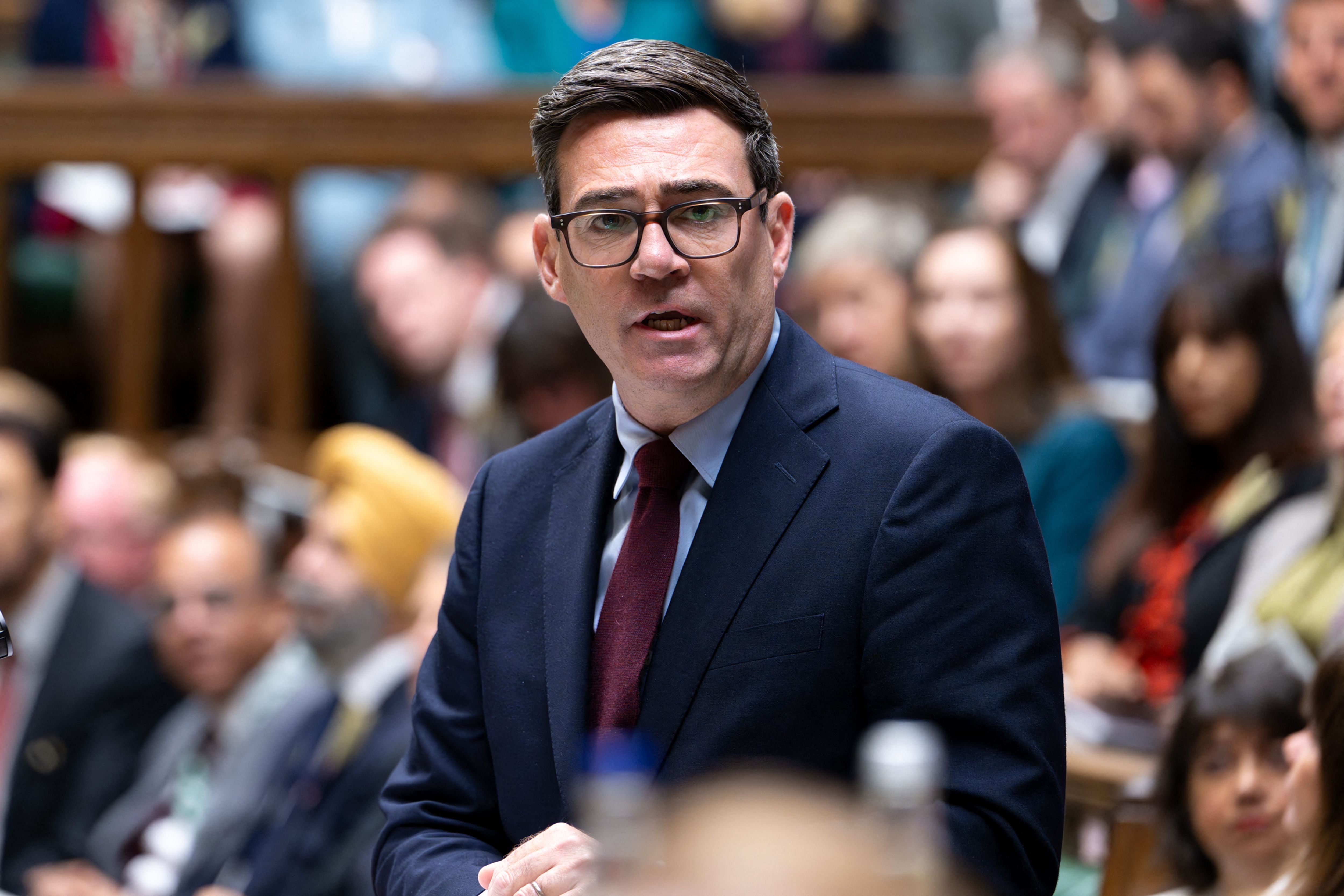 Ein Mann im Anzug spricht vor einer Menschenmenge im britischen Parlament.