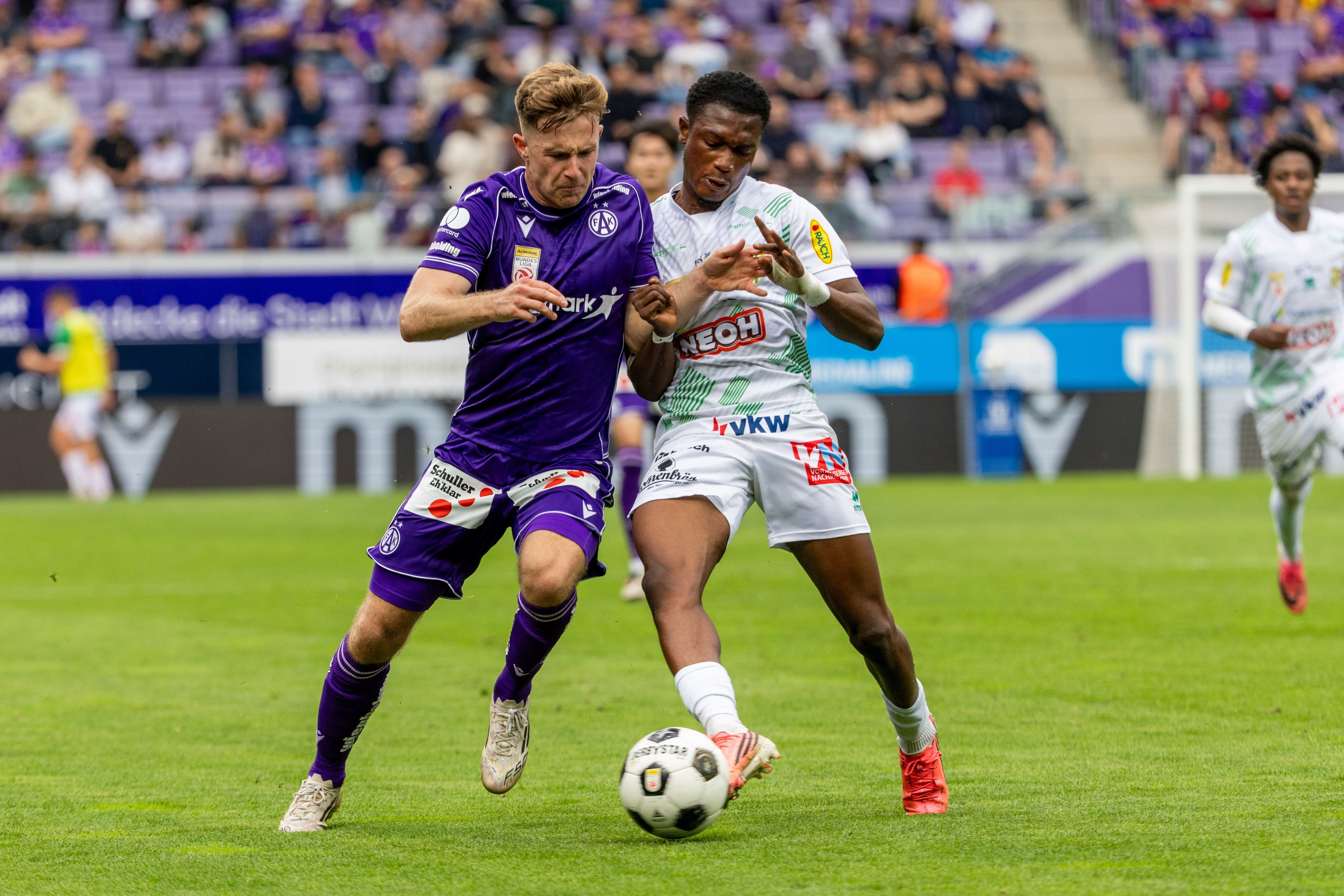 Zwei Fußballspieler kämpfen während eines Spiels um den Ball.