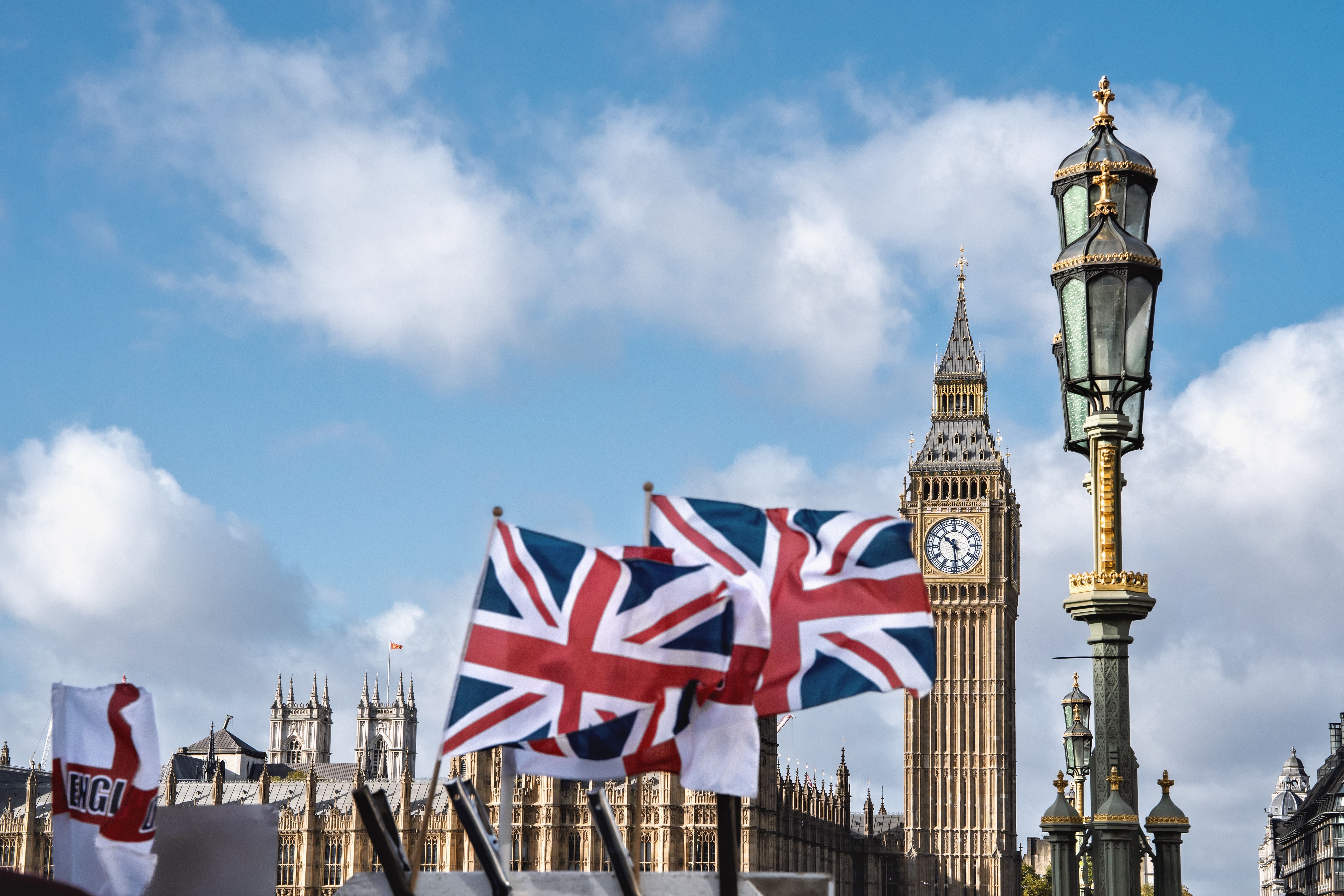 Ein Mann im Anzug spricht vor einer Menschenmenge im britischen Parlament.