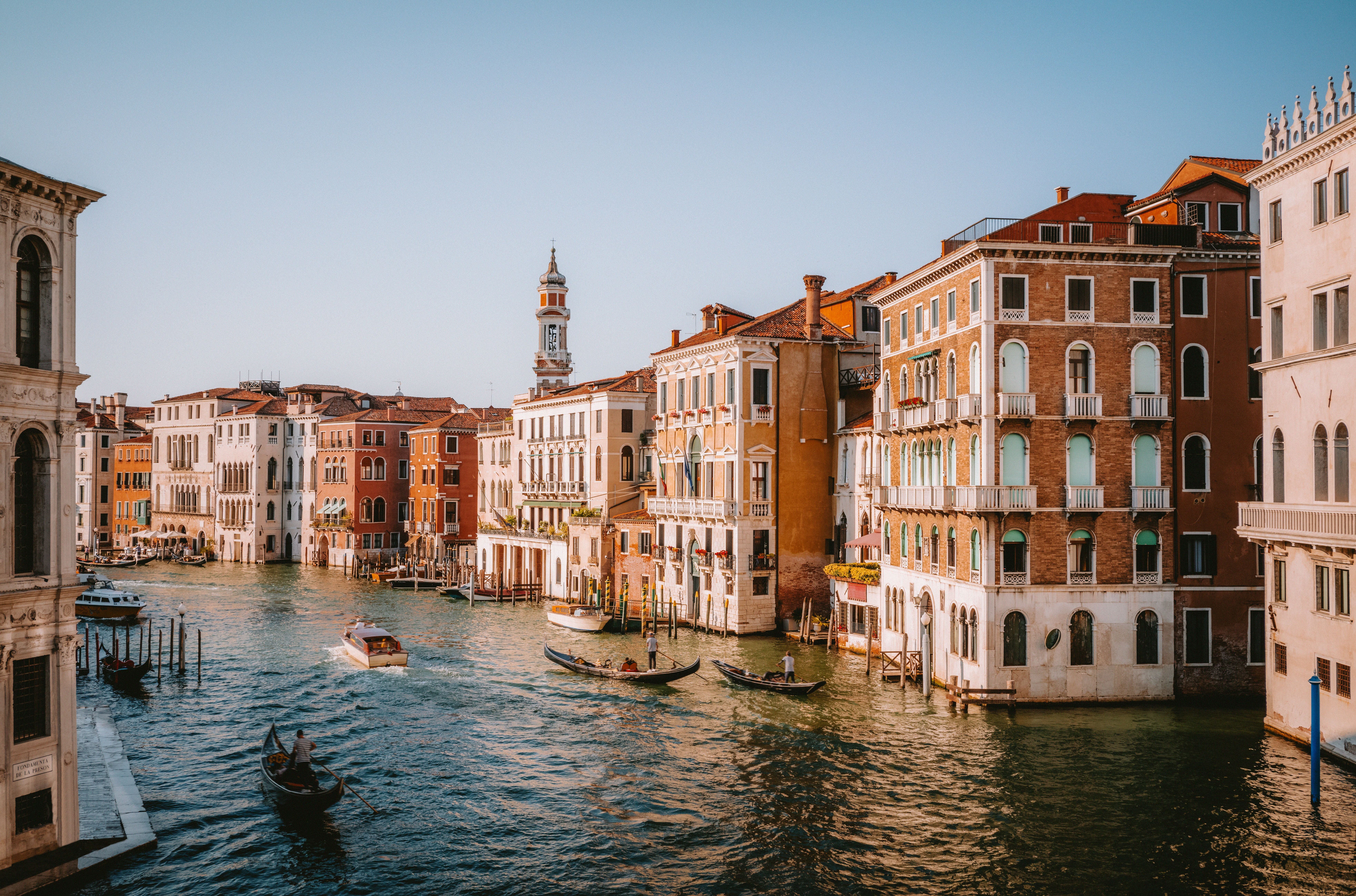 Gondeln fahren auf dem Canal Grande in Venedig mit historischen Gebäuden am Ufer.