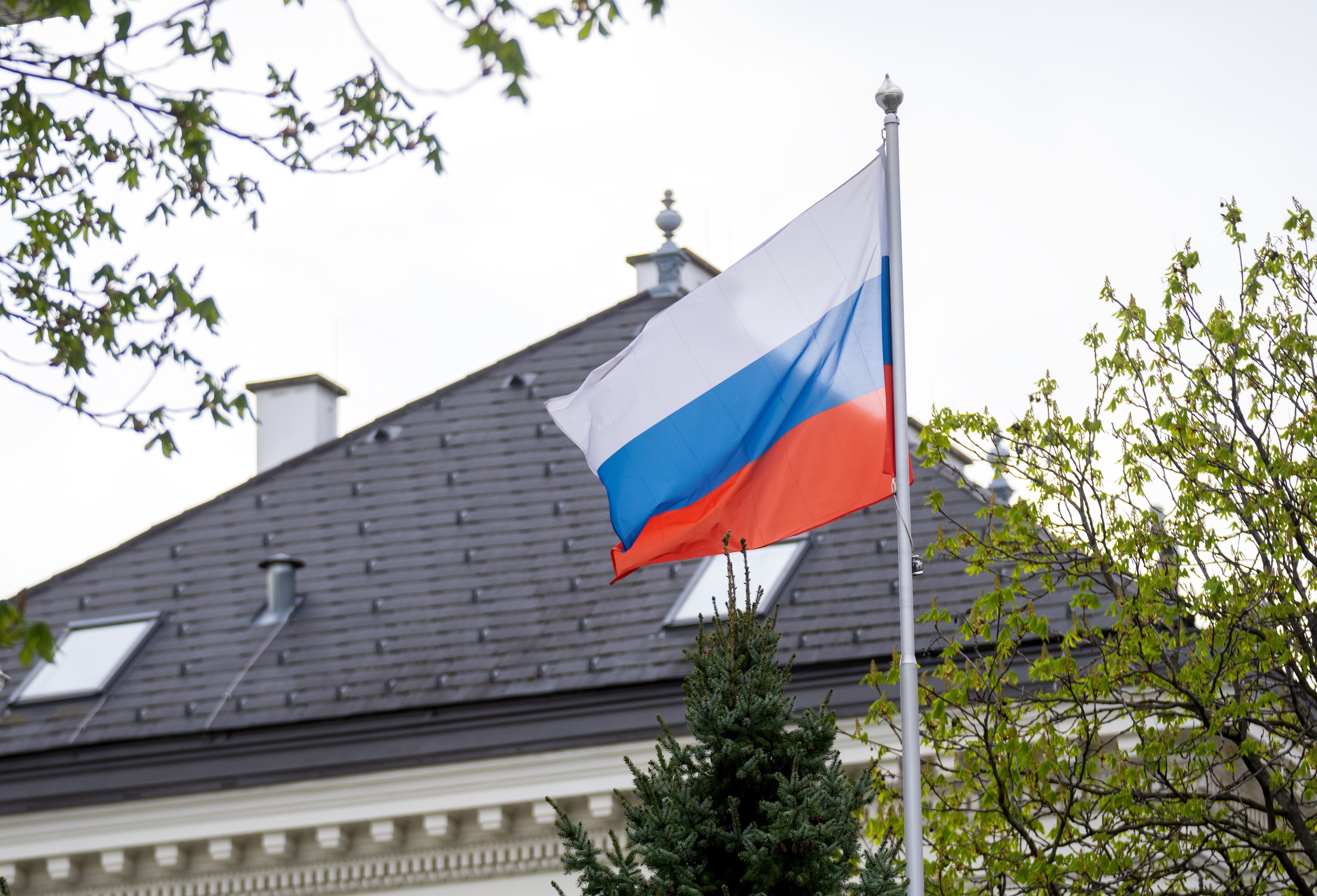 Die russische Flagge weht vor einem Gebäude und Bäumen in Wien.