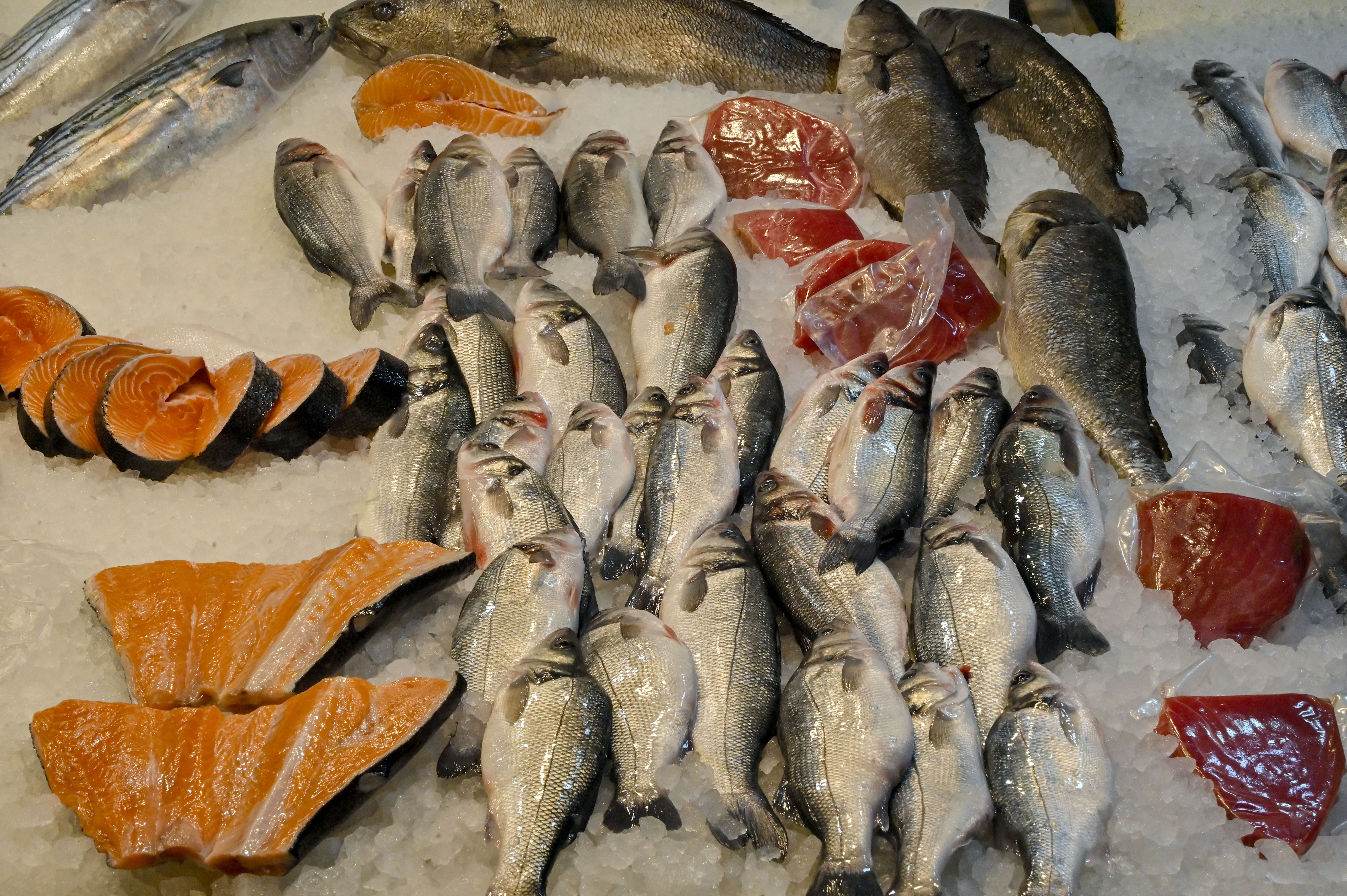 Frischer Fisch und Lachsfilets liegen auf Eis an einem Marktstand in Athen.