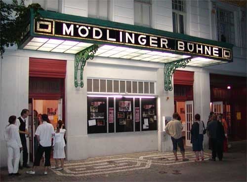Menschen stehen abends vor dem beleuchteten Eingang der Mödlinger Bühne in Mödling.