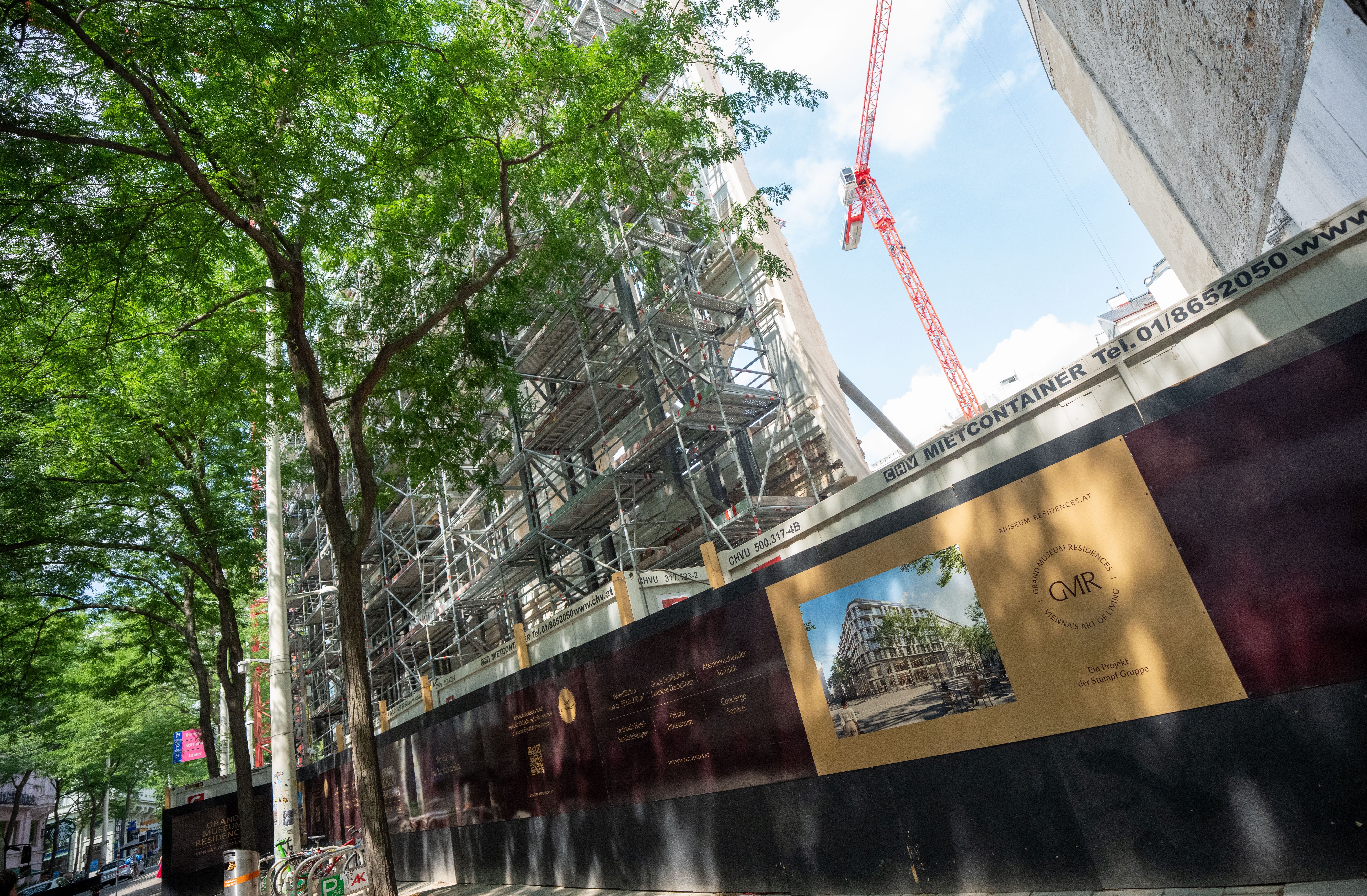 Blick auf eine Baustelle mit Bauzaun und Werbeschild für die Grand Museum Residences in Wien.
