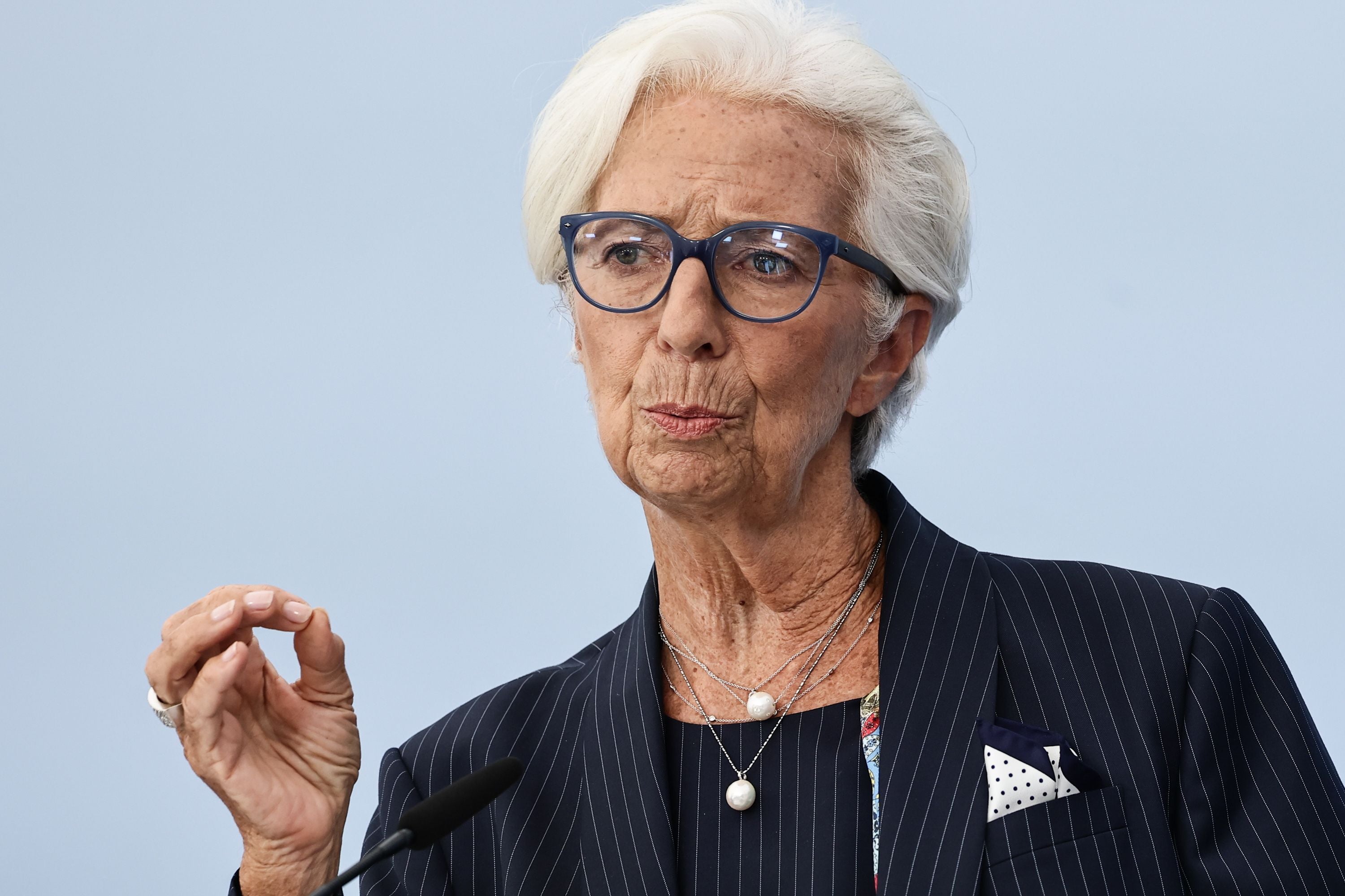 Eine ältere Frau mit weißem Haar und Brille spricht bei einer Pressekonferenz am Mikrofon.