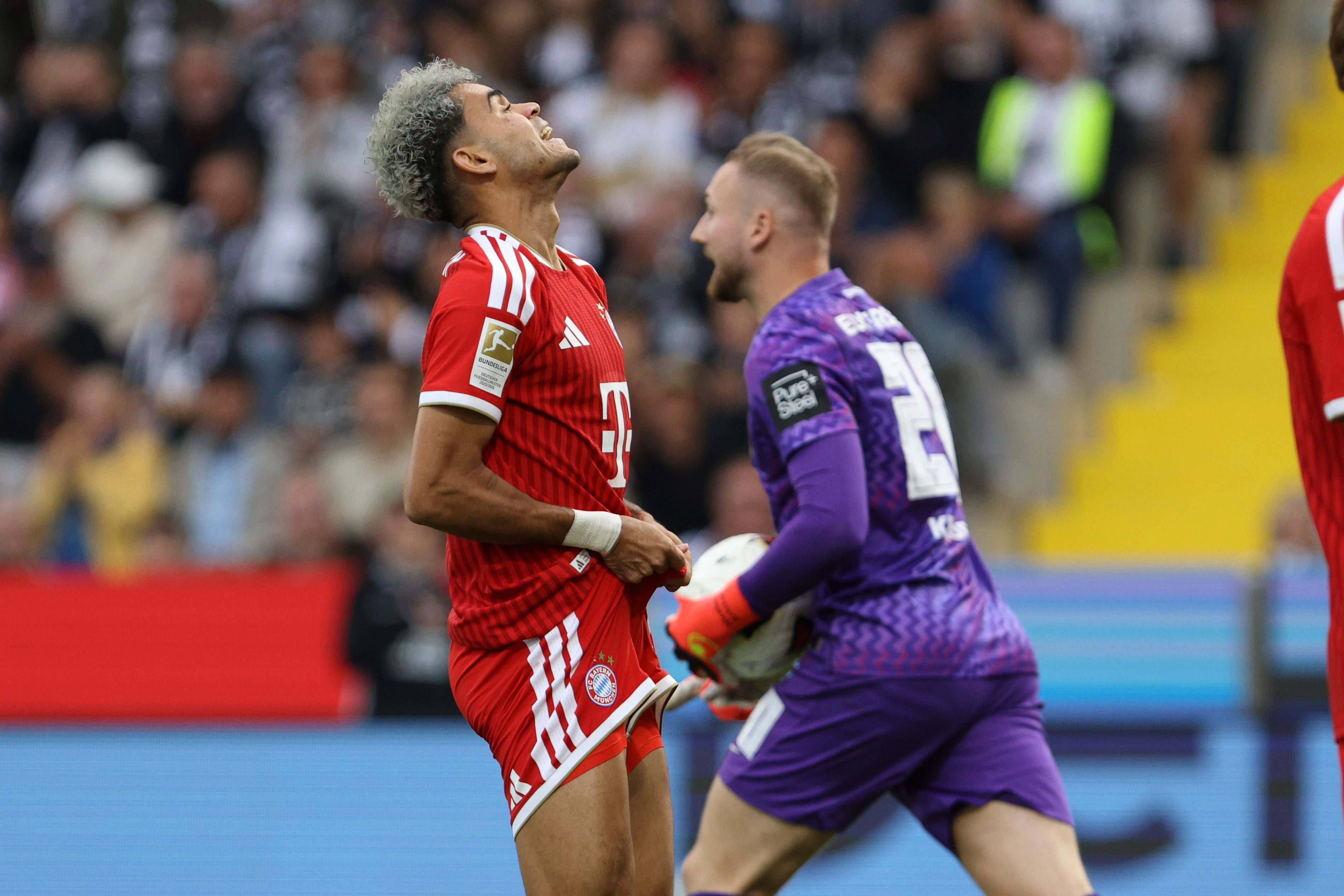 Ein frustrierter Bayern-Spieler steht neben einem Torwart im lila Trikot während eines Fußballspiels.