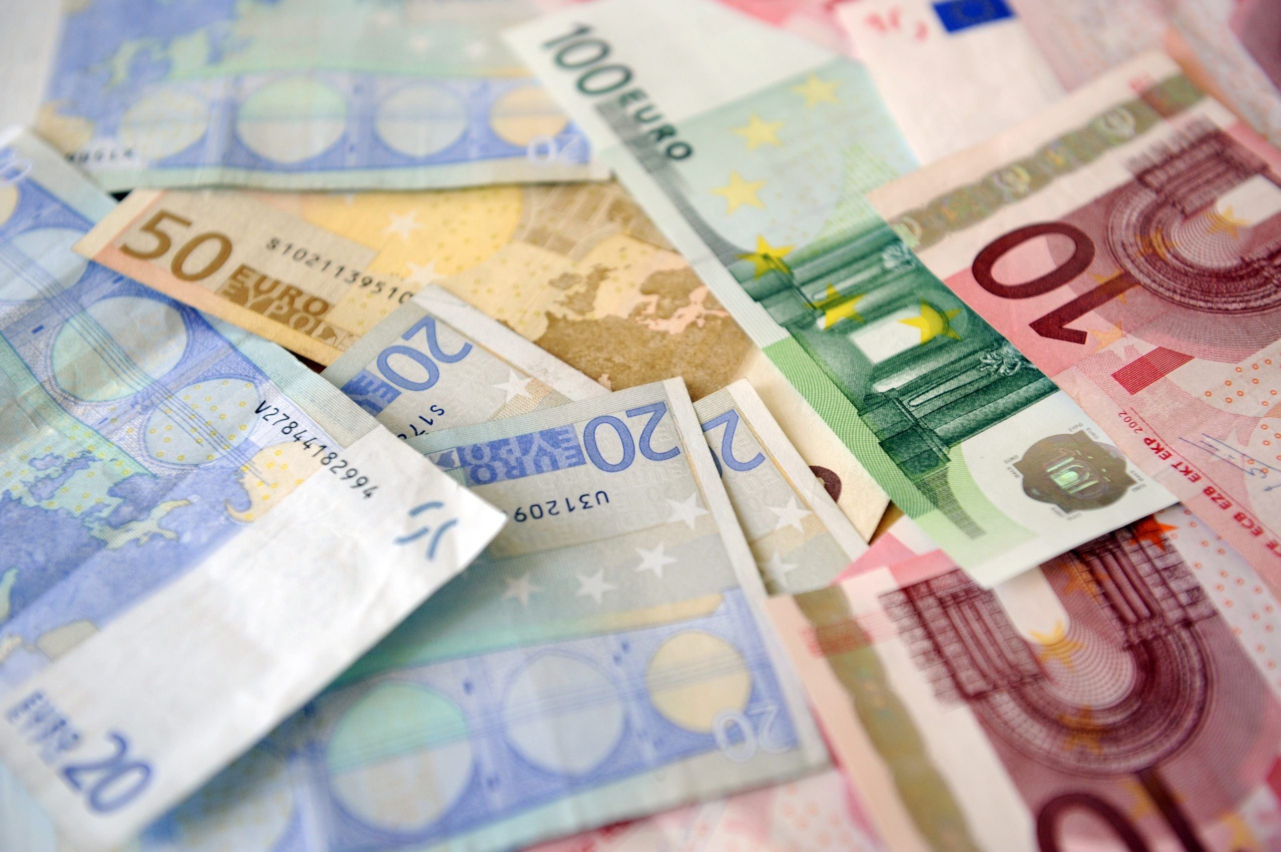 Mehrere Euro-Geldscheine in verschiedenen Stückelungen liegen übereinander verstreut.