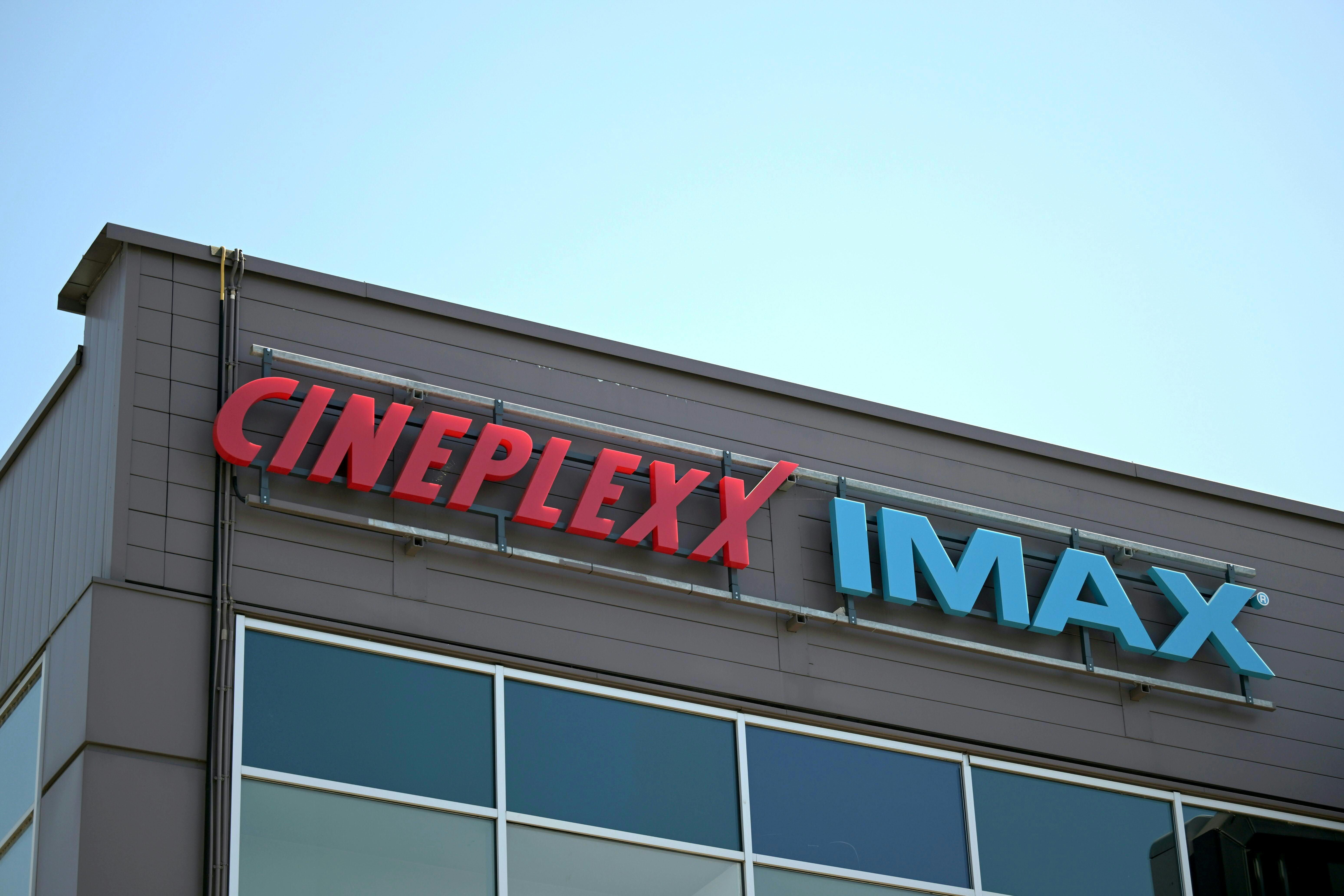 Das Logo von Cineplexx und IMAX an der Fassade eines Gebäudes bei Tageslicht.