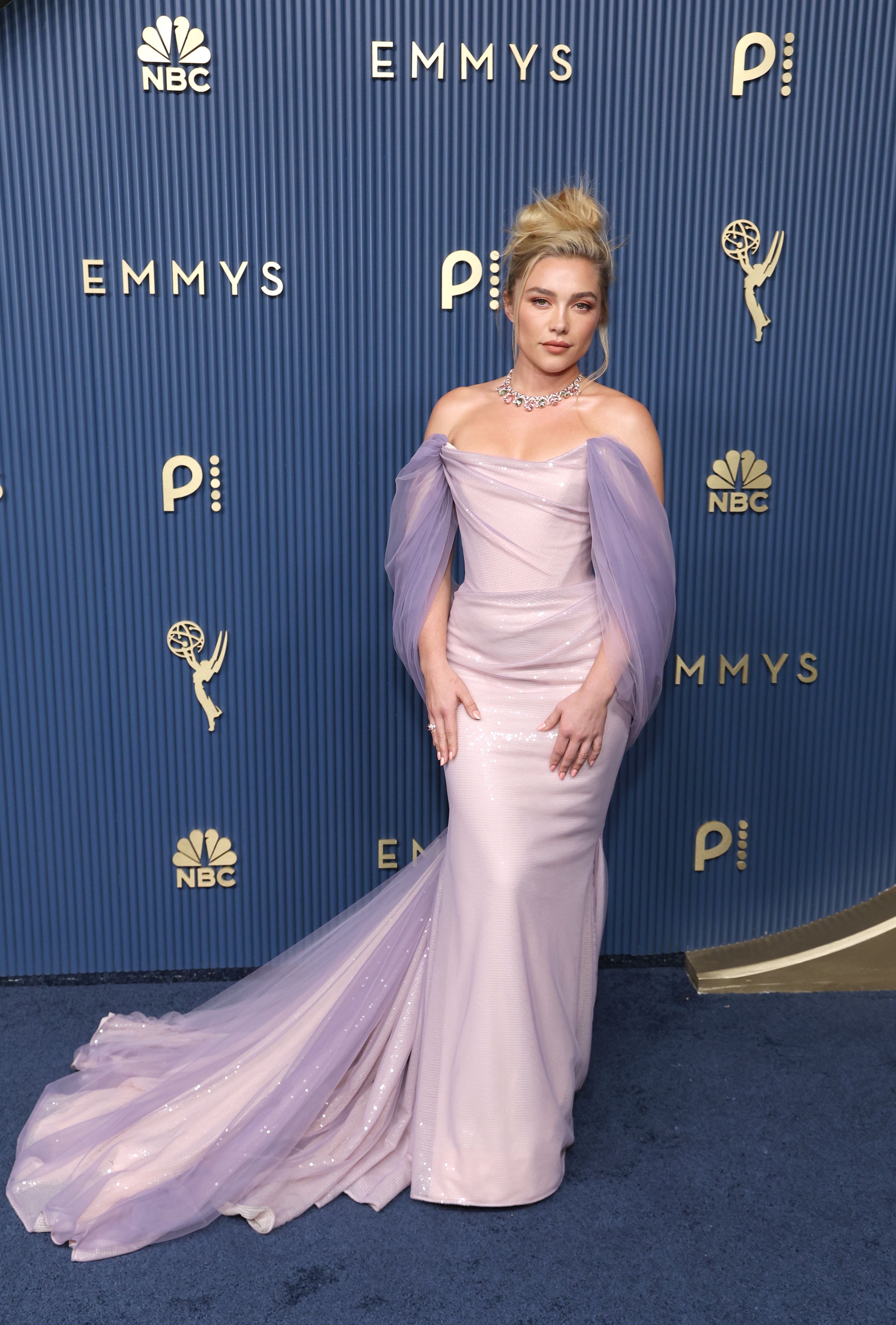Frau im eleganten, lilafarbenen Abendkleid auf dem blauen Teppich der Emmy Awards.