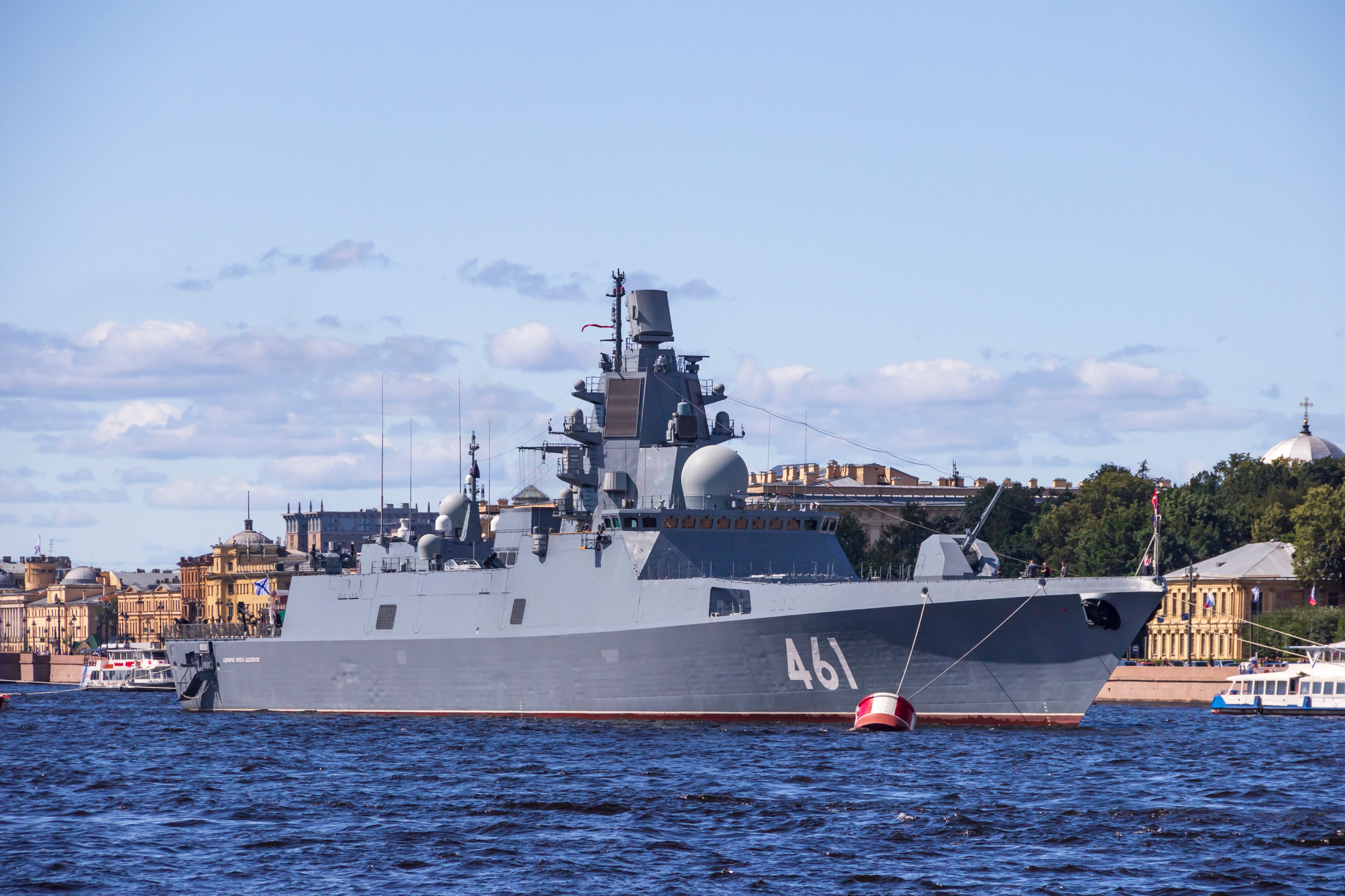 Graues Kriegsschiff mit der Nummer 461 am Wasser in St. Petersburg, Gebäude im Hintergrund.