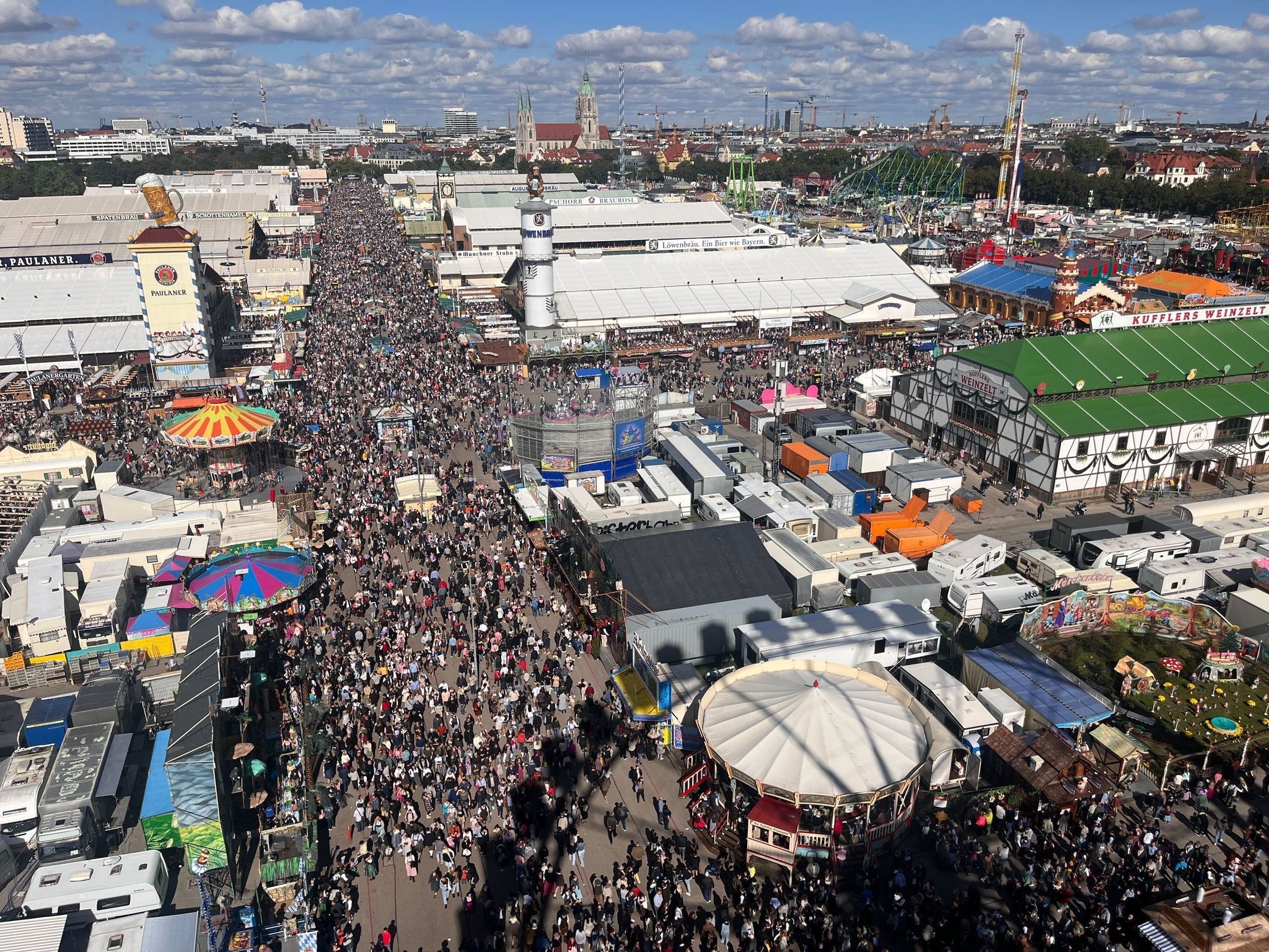 Menschenmassen auf dem Oktoberfest in München, fotografiert aus der Höhe mit Blick auf Festzelte.