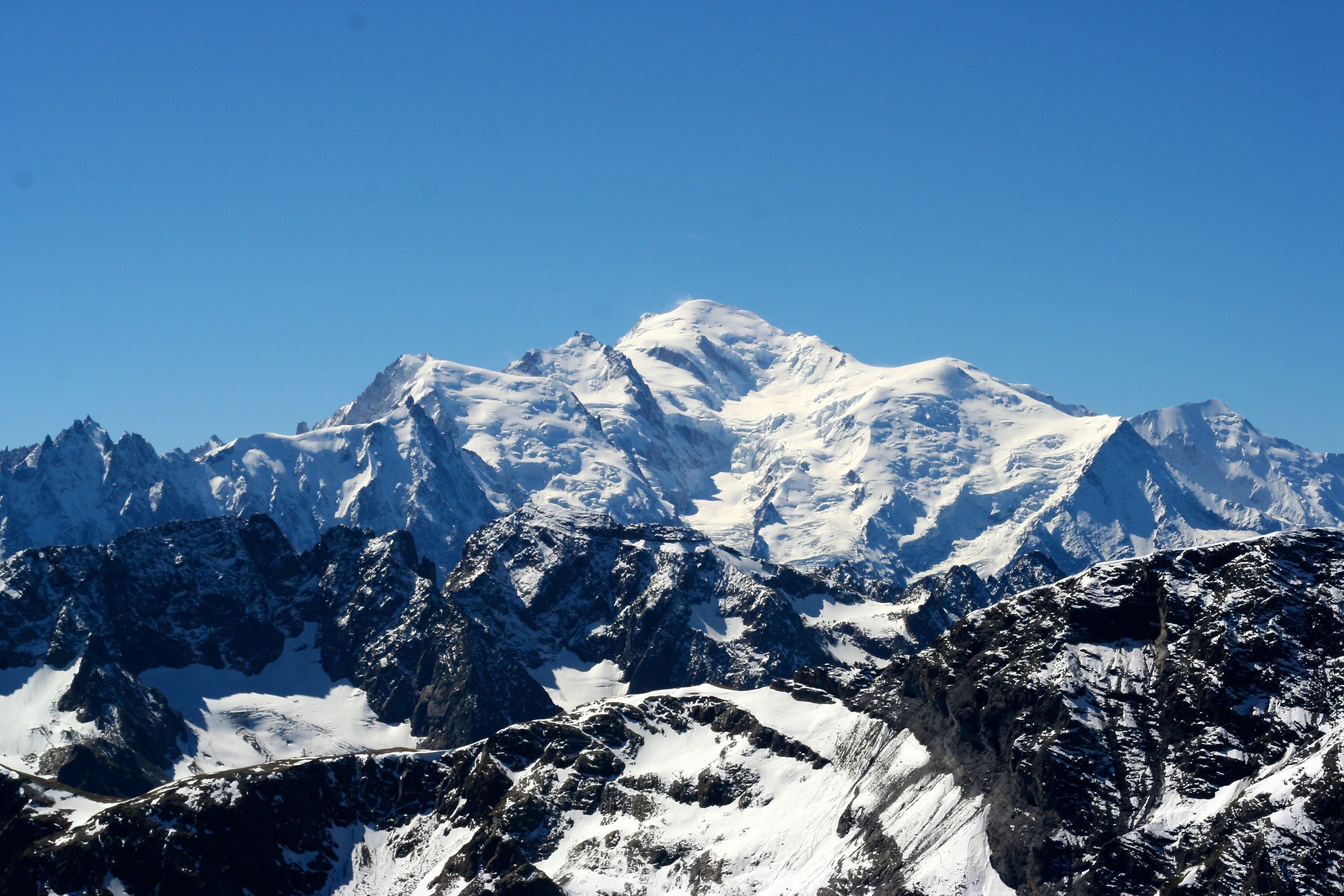 Verschneiter Mont Blanc mit blauem Himmel im Hintergrund.