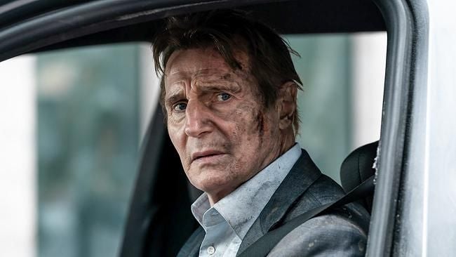 Mann mit schmutzigem Gesicht sitzt im Auto und schaut ernst aus dem Fenster.