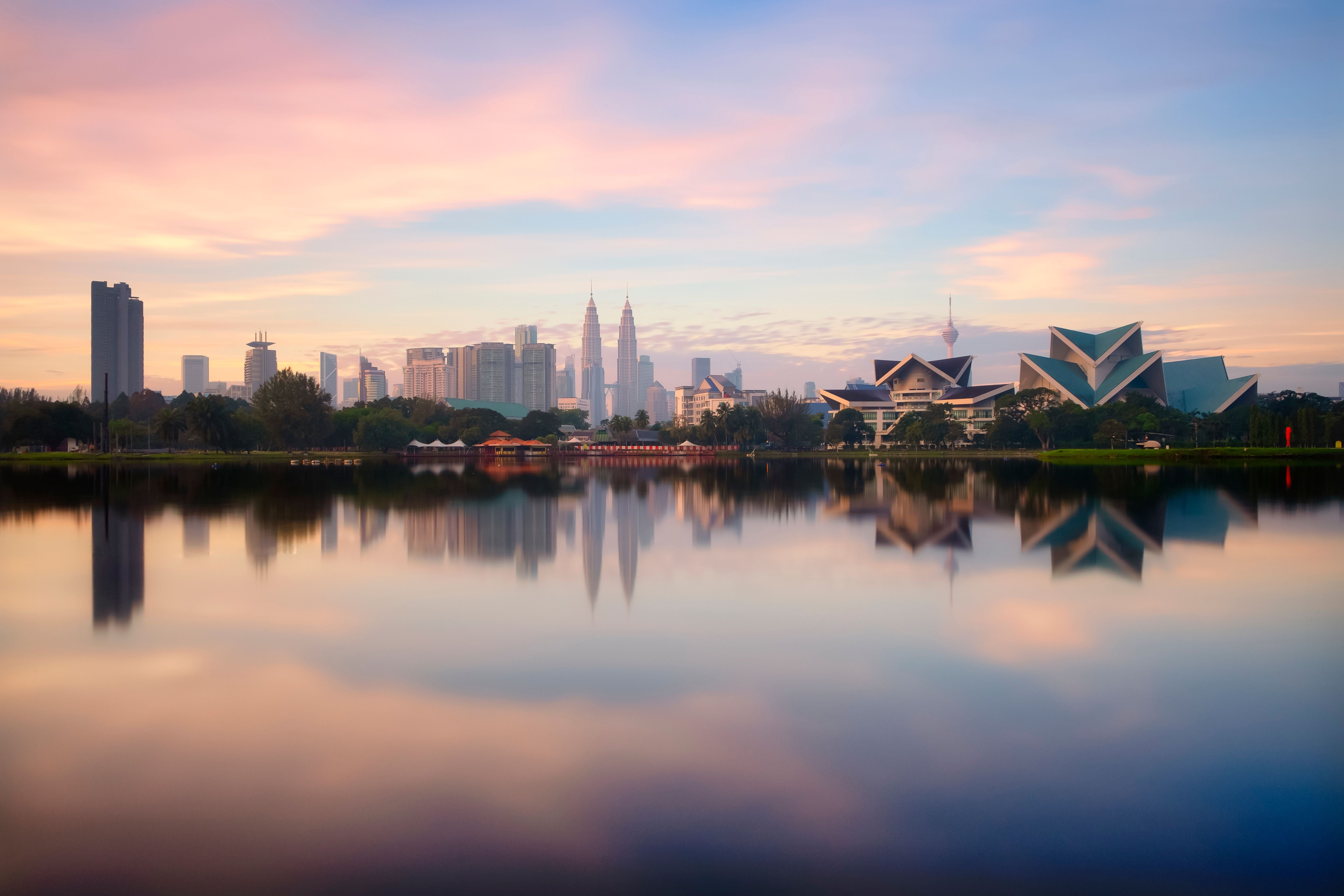 Panorama von Kuala Lumpur spiegelt sich im See im Titiwangsa-Park bei Sonnenuntergang.