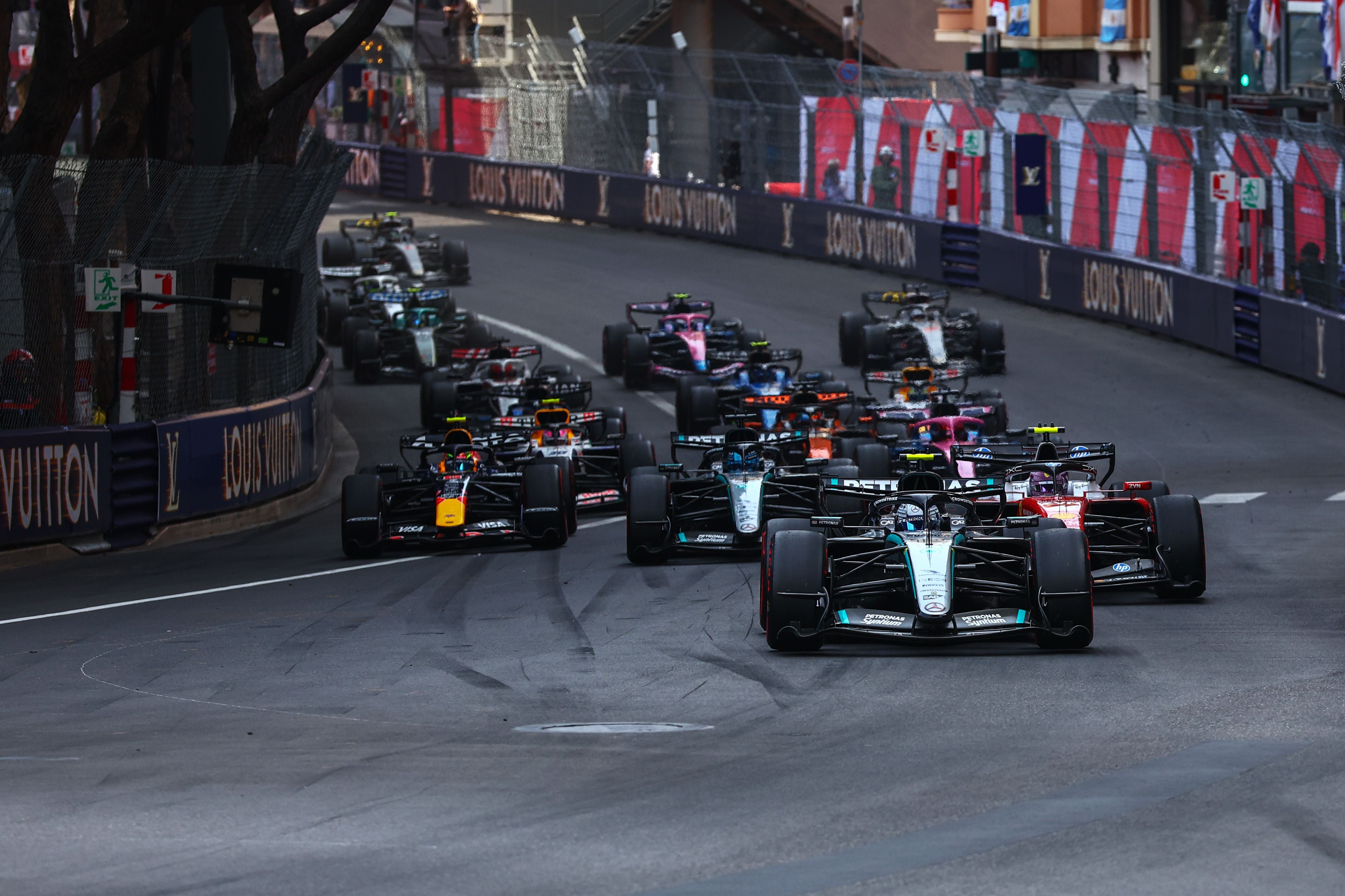 Formel-1-Fahrzeuge fahren dicht beieinander beim Neustart des Monaco-Grand-Prix durch eine Kurve.