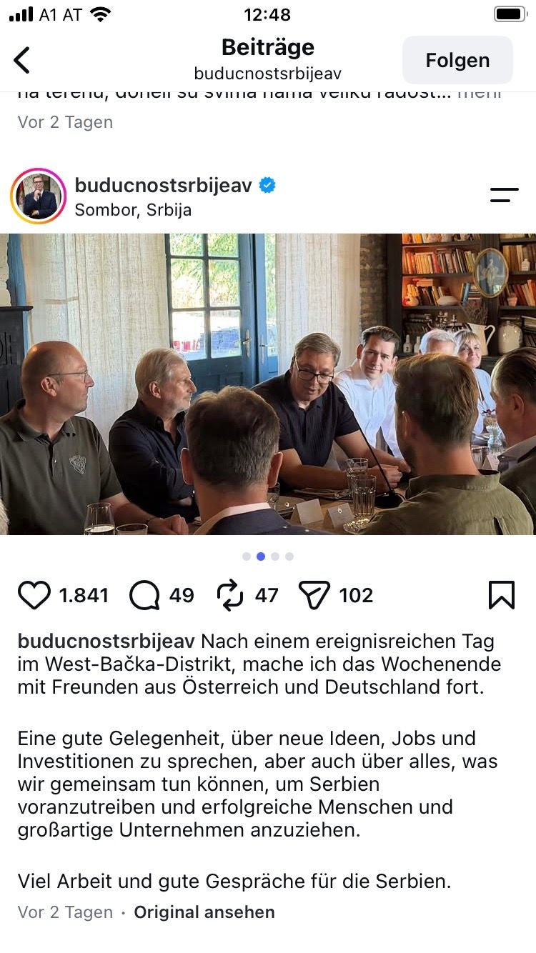 Mehrere Männer sitzen an einem Tisch und führen ein Gespräch in einem gemütlichen Raum.