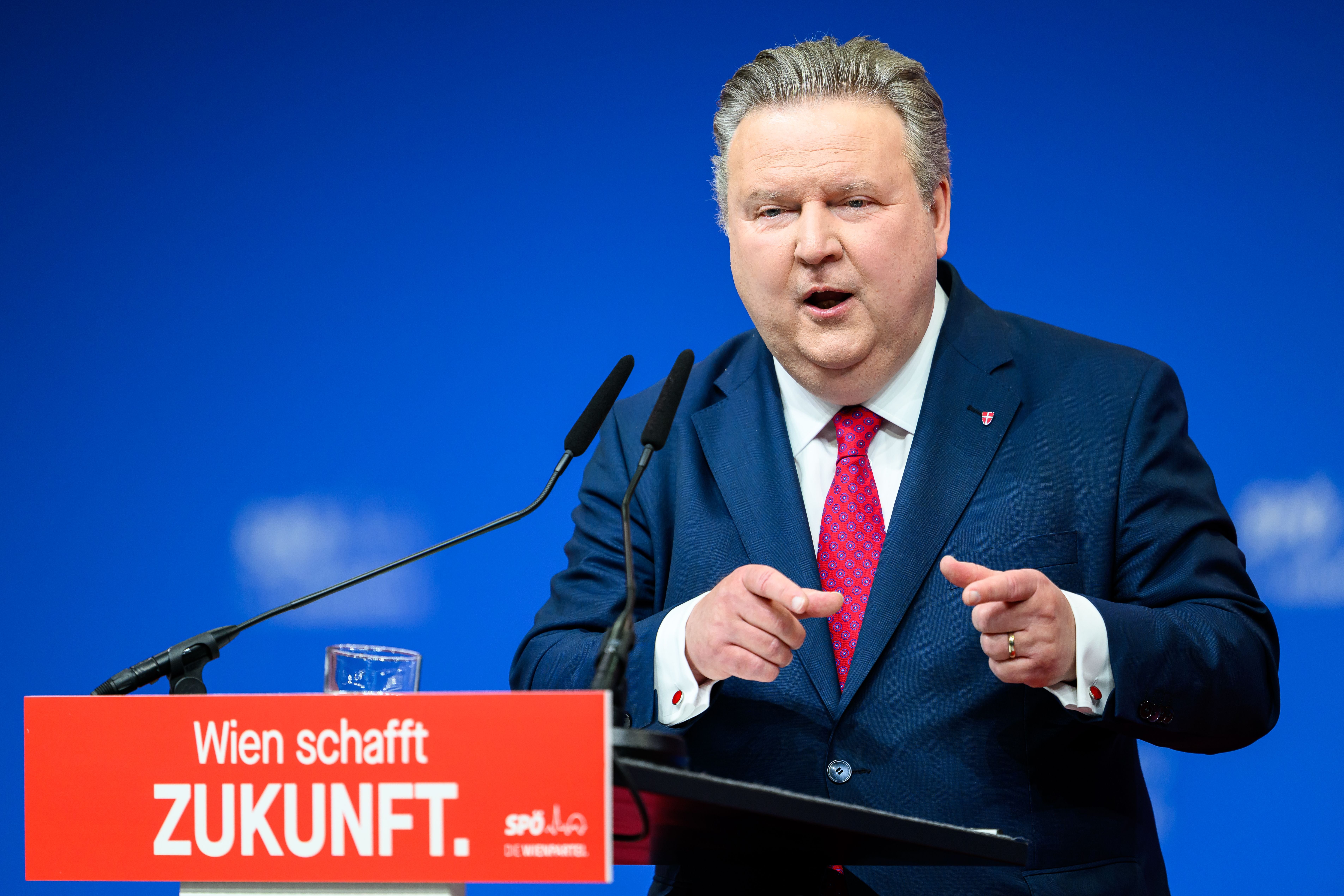 Ein Mann im Anzug spricht bei einer SPÖ-Veranstaltung an einem Rednerpult mit rotem Schild.