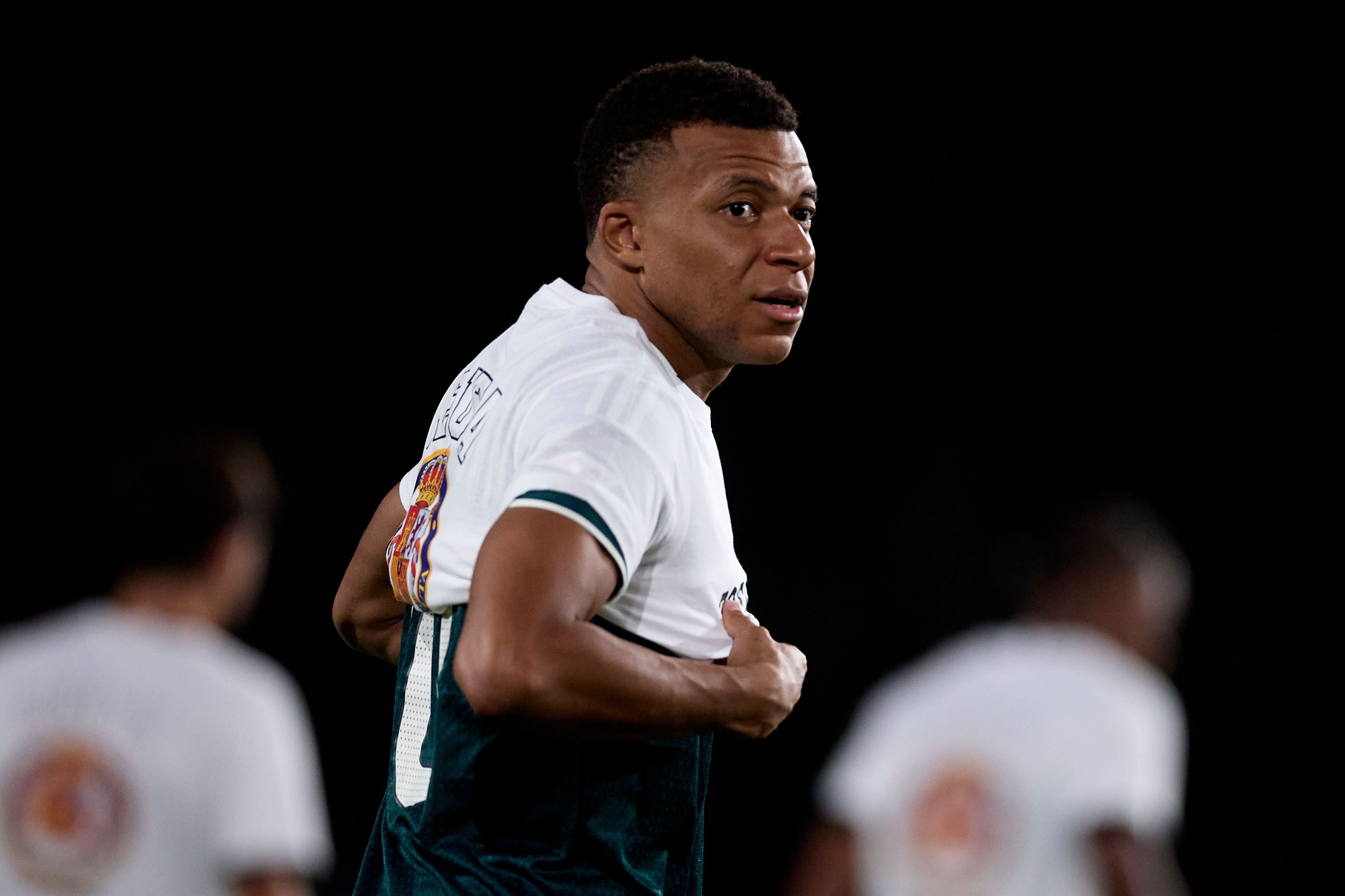 Kylian Mbappé trägt ein spezielles Real-Madrid-Trikot vor einem Fußballspiel.