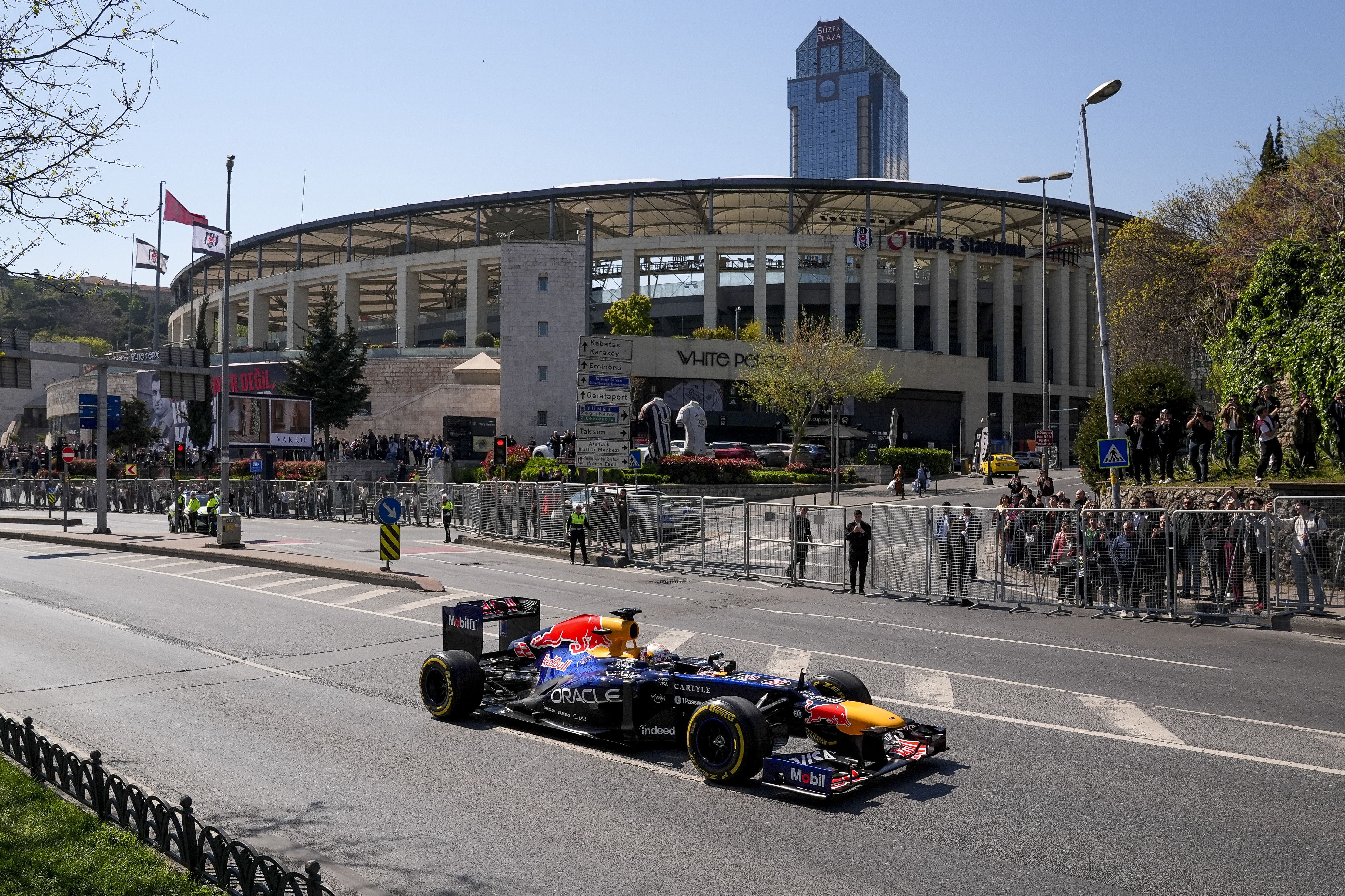 Ein Formel-1-Rennwagen von Red Bull Racing fährt auf einer abgesperrten Stadtstraße in Istanbul vor Zuschauern und dem Besiktas-Stadion.
