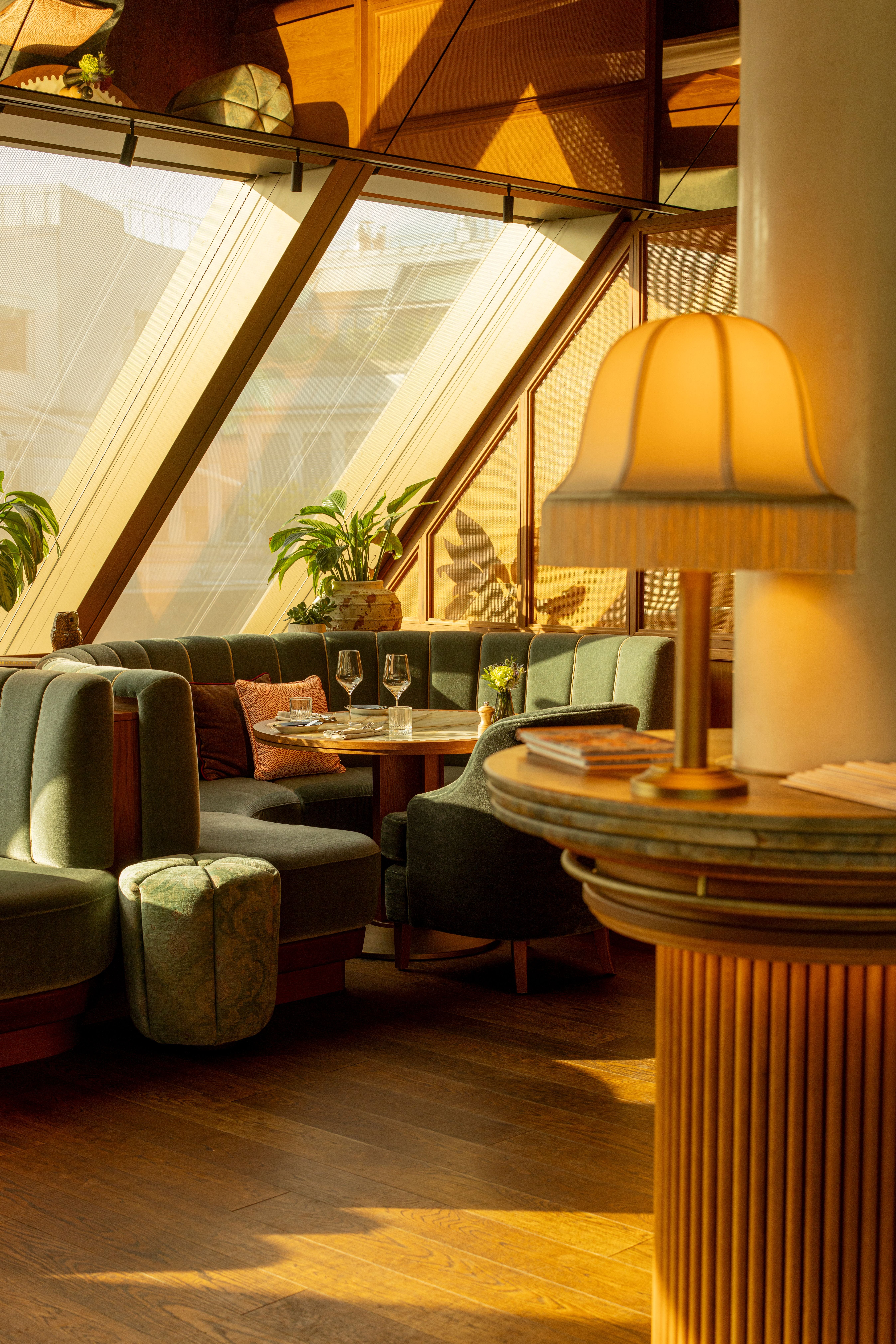 Gemütliche Sitzecke in einem Restaurant mit stilvoller Beleuchtung und großen Fenstern bei Sonnenlicht.