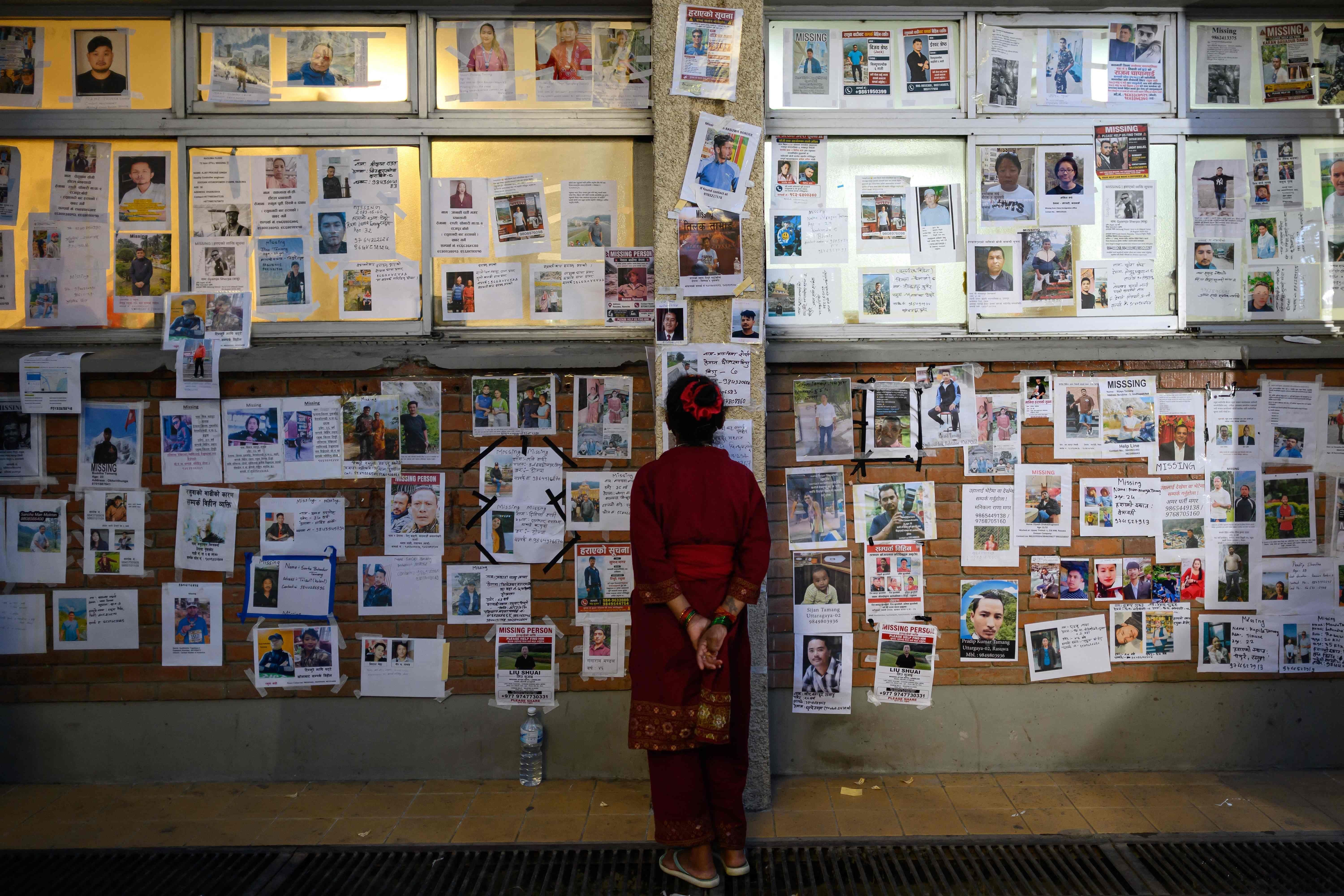 Eine Frau betrachtet vermissten Anzeigen an einer Wand im Krankenhaus in Kathmandu.