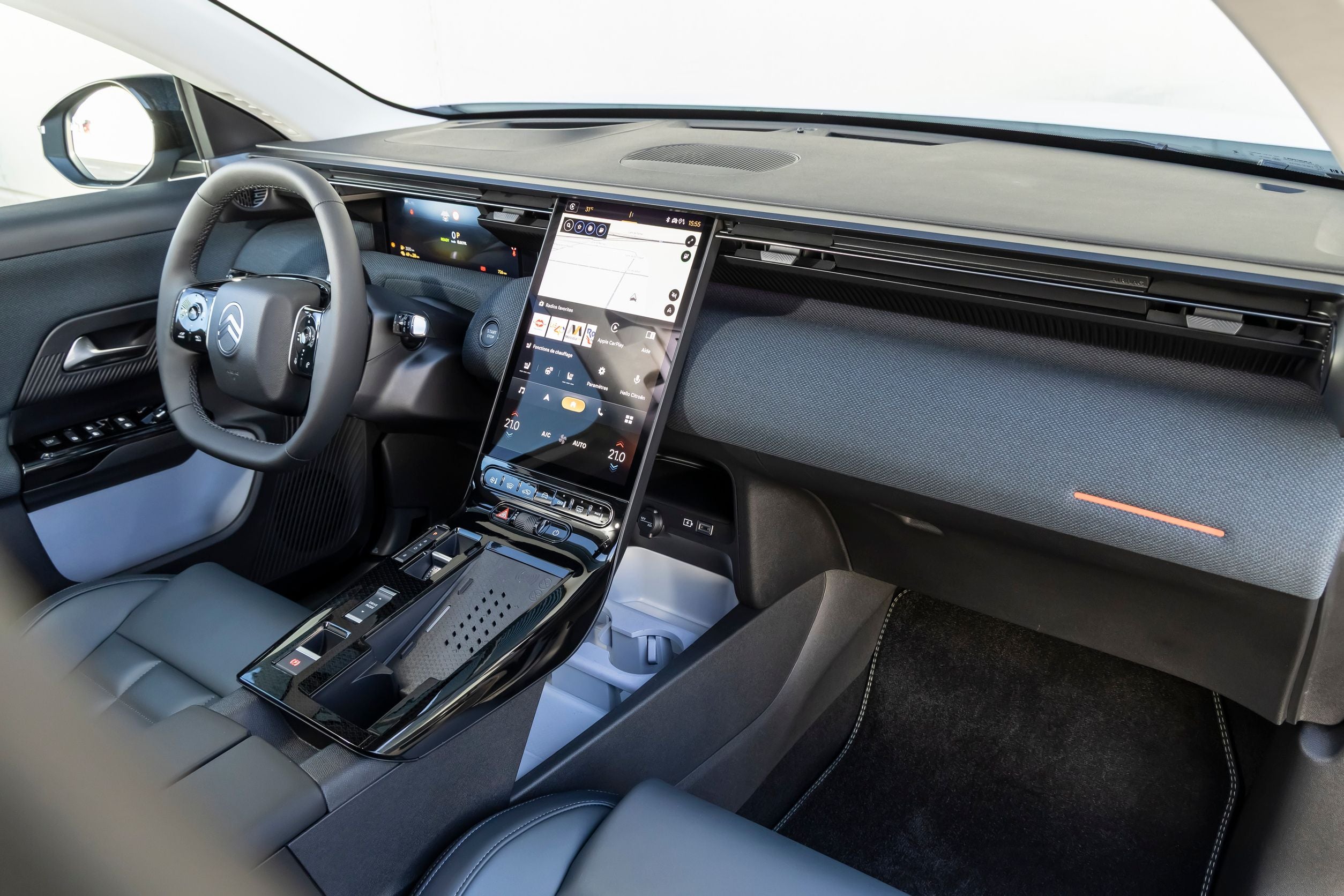 Modernes Auto-Cockpit mit großem Touchscreen und digitalem Display hinter dem Lenkrad.