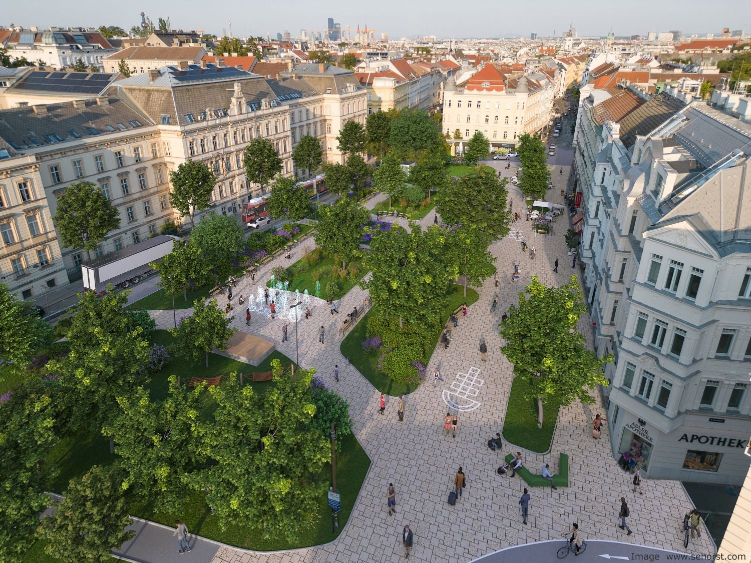 Luftaufnahme vom begrünten Aumannplatz mit Fußgängern, Bäumen und Sitzbereichen in Wien.