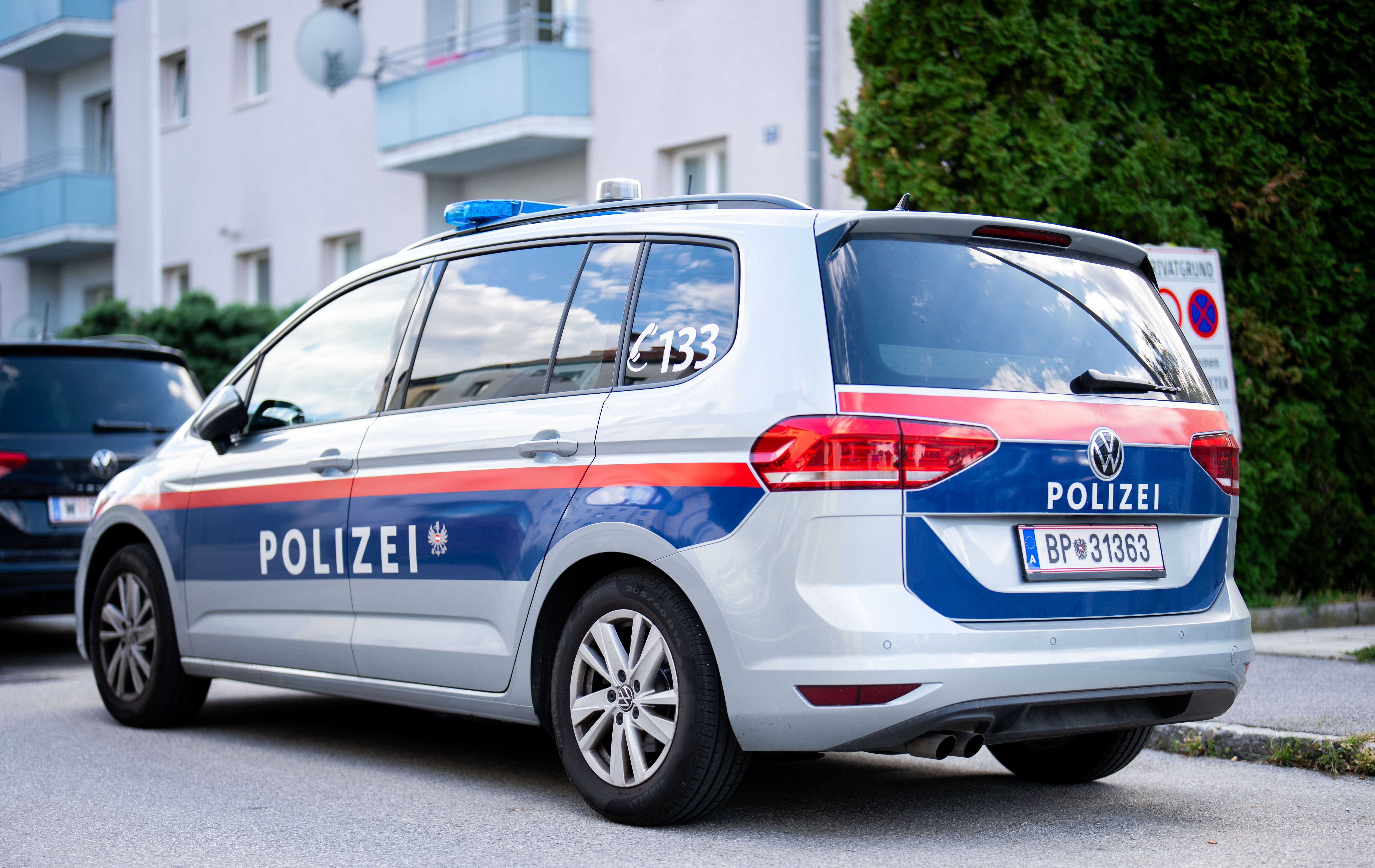 Österreichisches Polizeiauto steht auf einer Straße vor Wohnhäusern in Bad Vöslau.