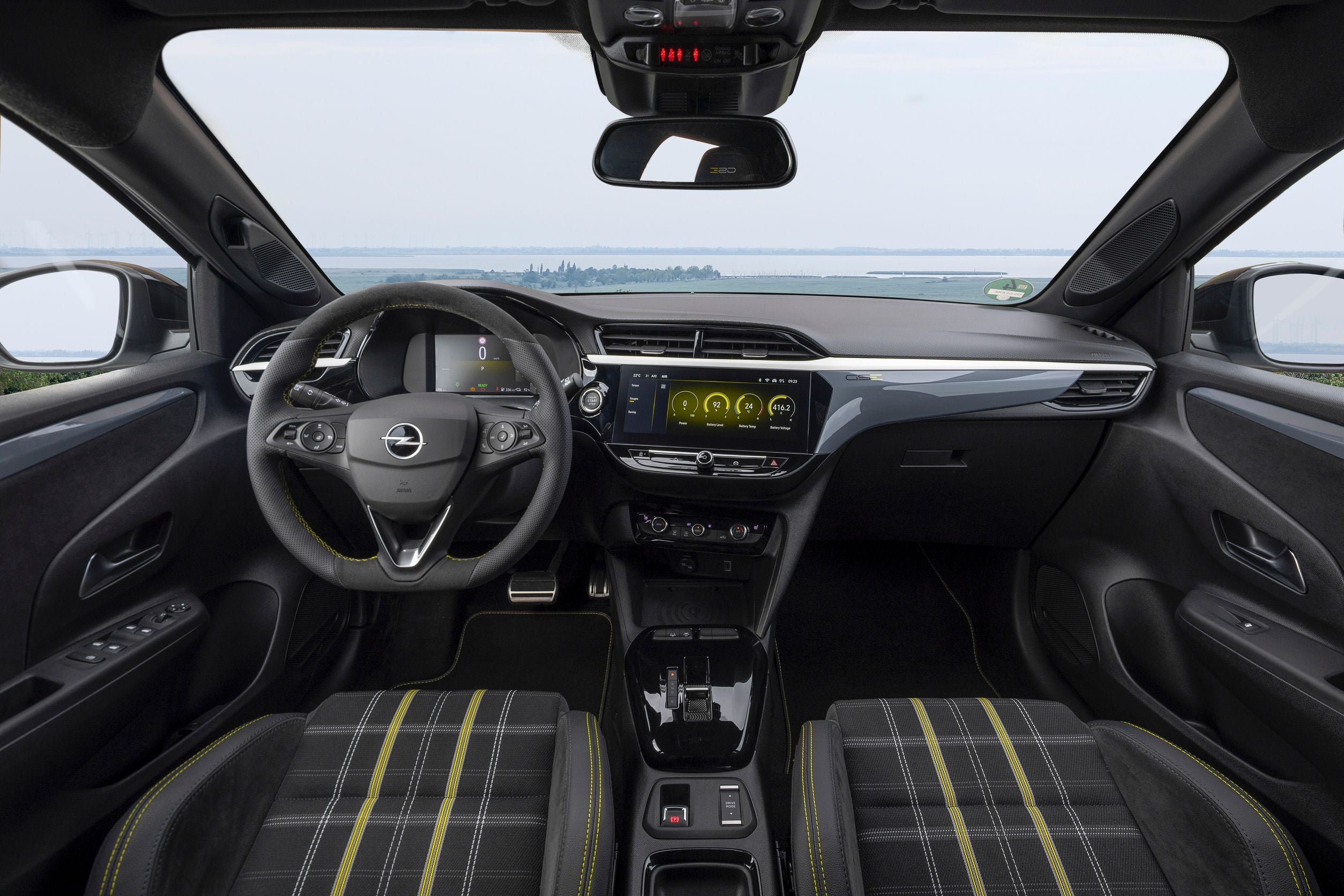 Modernes Cockpit eines Opel mit digitalem Display und Stoff-Sportsitzen in Schwarz mit gelben Nähten.