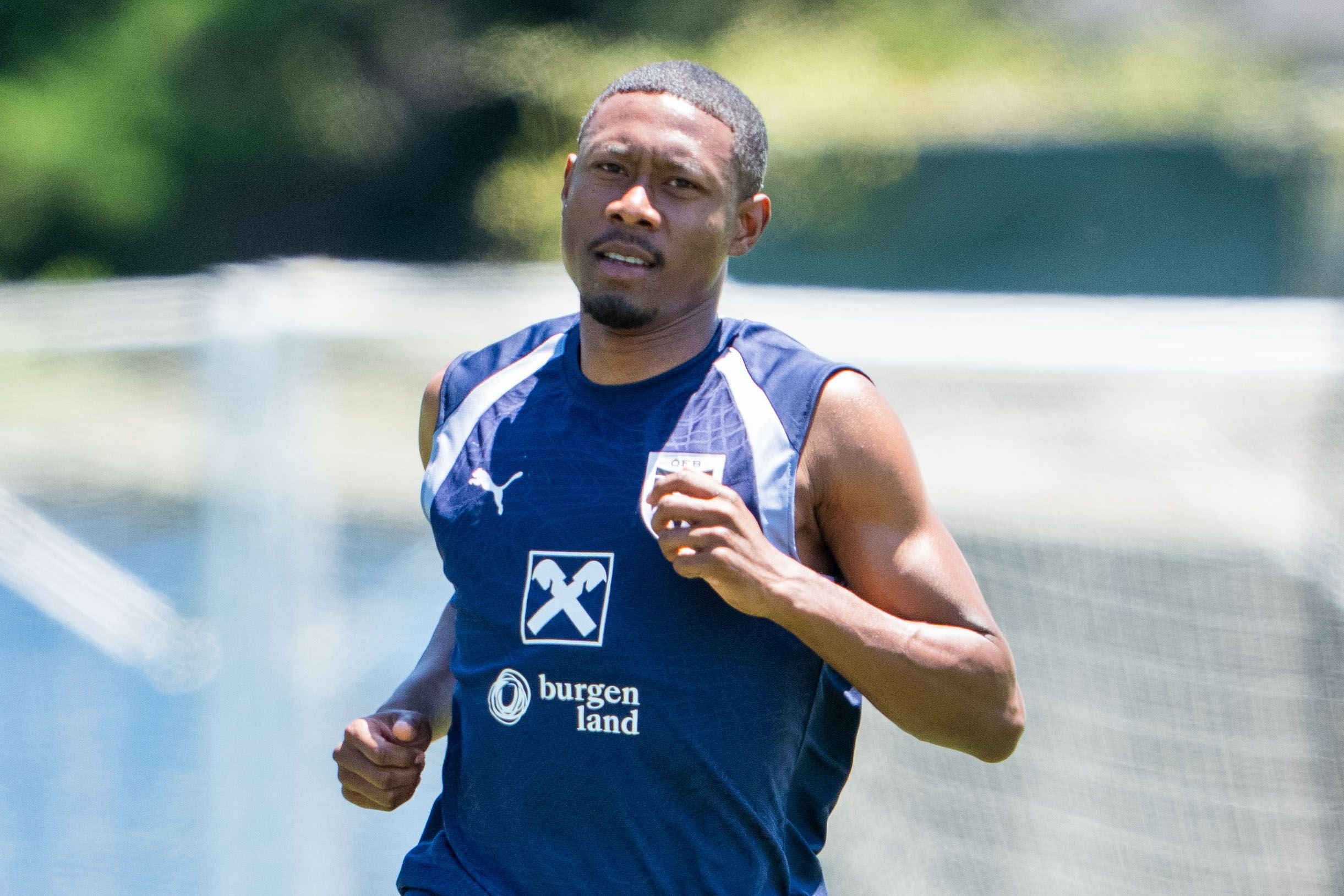 Ein Fußballspieler im blauen Trainingsshirt läuft beim Training im Freien.