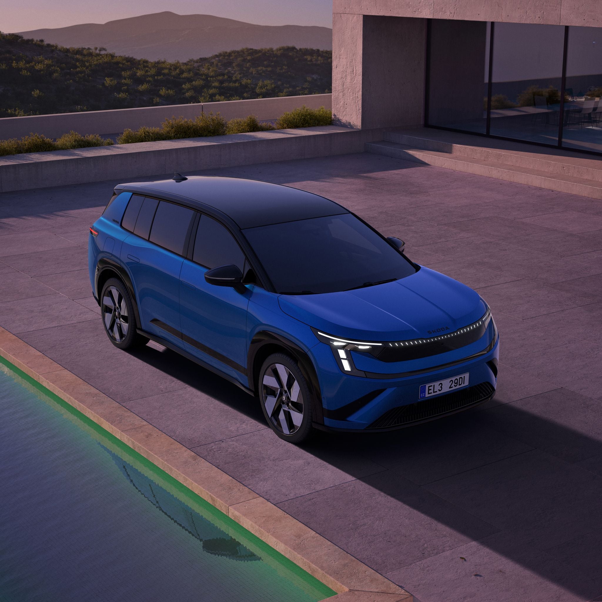 Blauer SUV parkt neben einem Pool vor einem modernen Haus im Abendlicht.