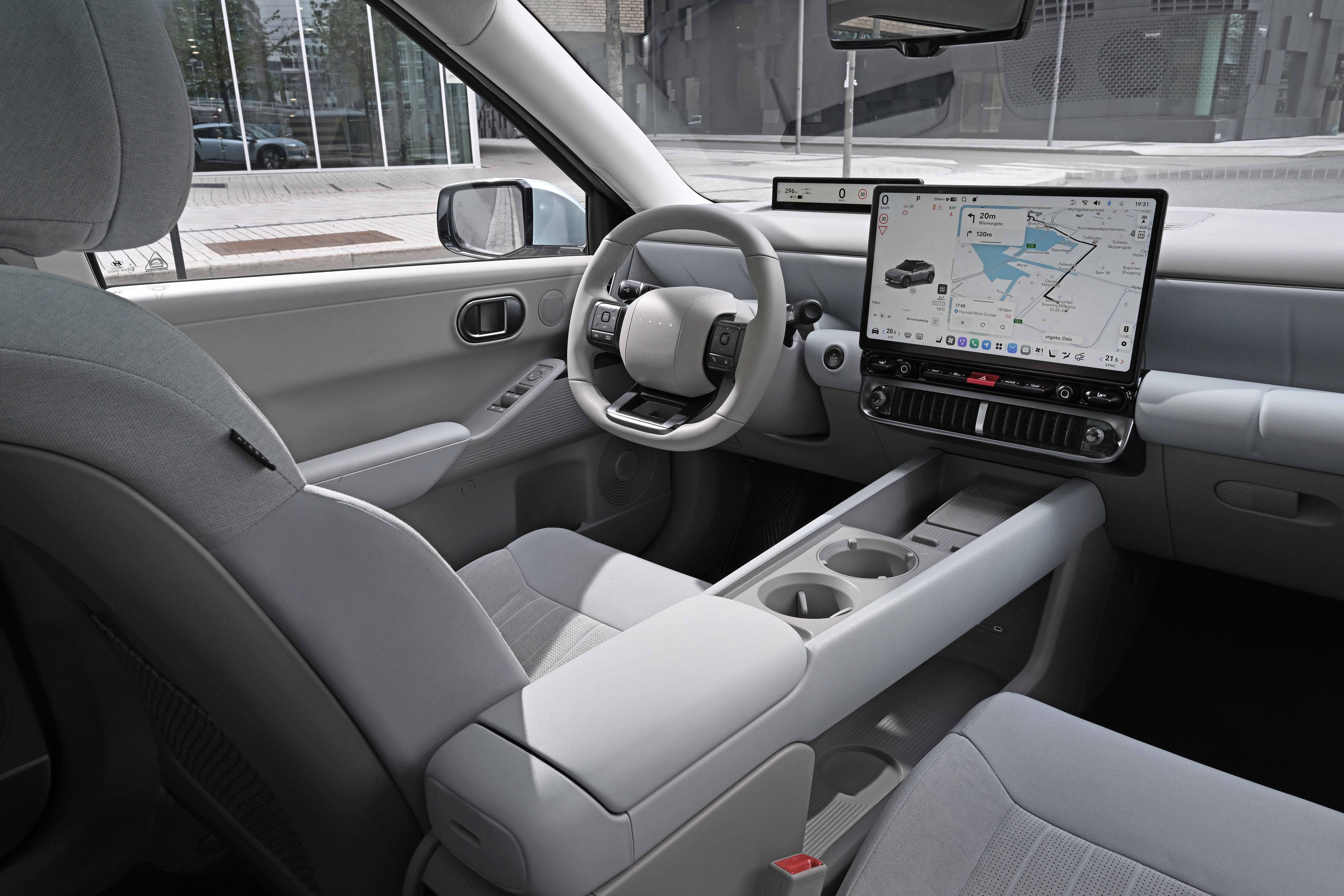 Modernes Autointerieur mit großem Touchscreen und hellem, minimalistischem Design.