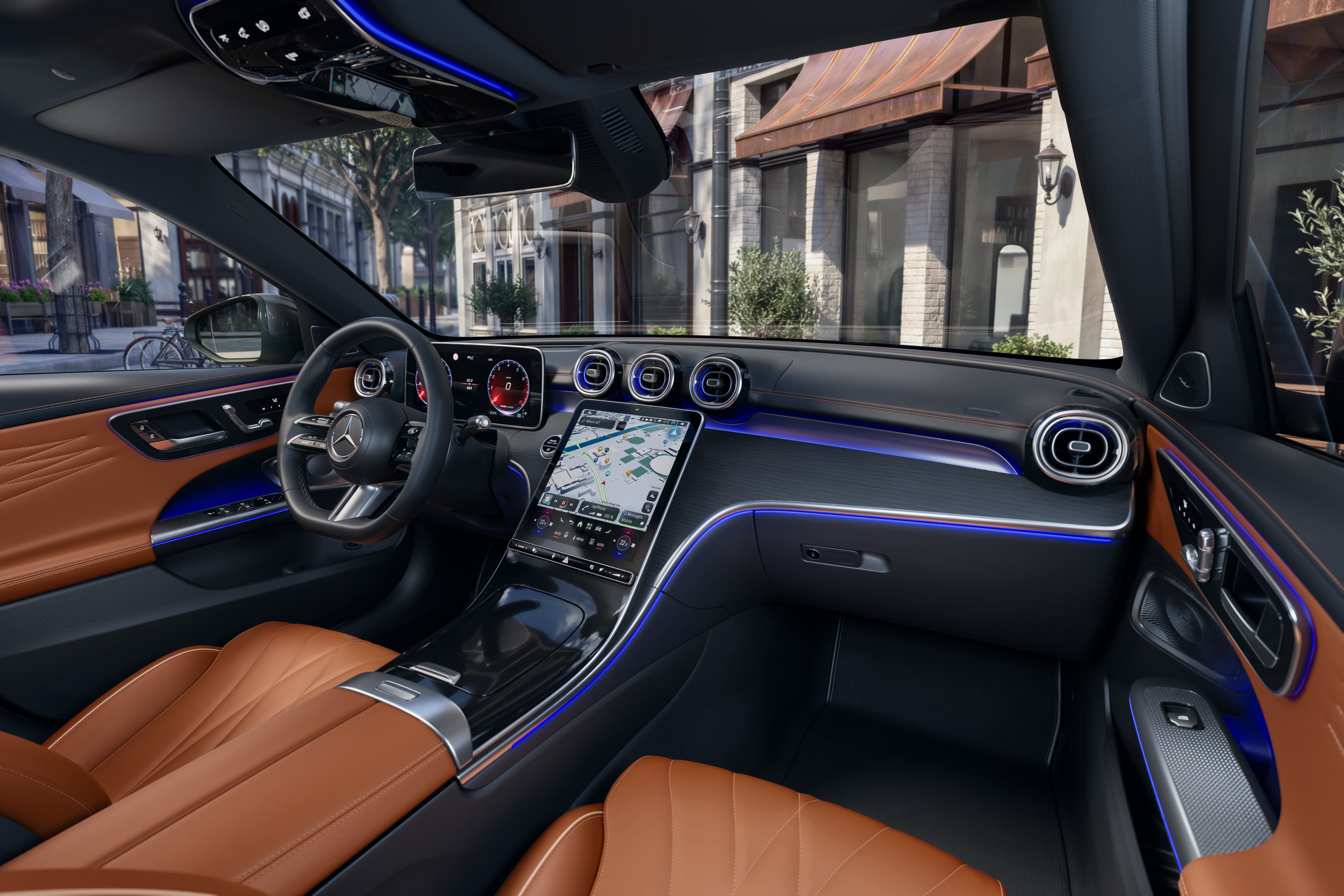 Innenraum einer neuen Mercedes-Benz C-Klasse Limousine mit braunen Ledersitzen und großem Touchdisplay.