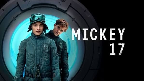 Zwei Männer in Raumanzügen vor einem runden Portal mit dem Schriftzug "Mickey 17".