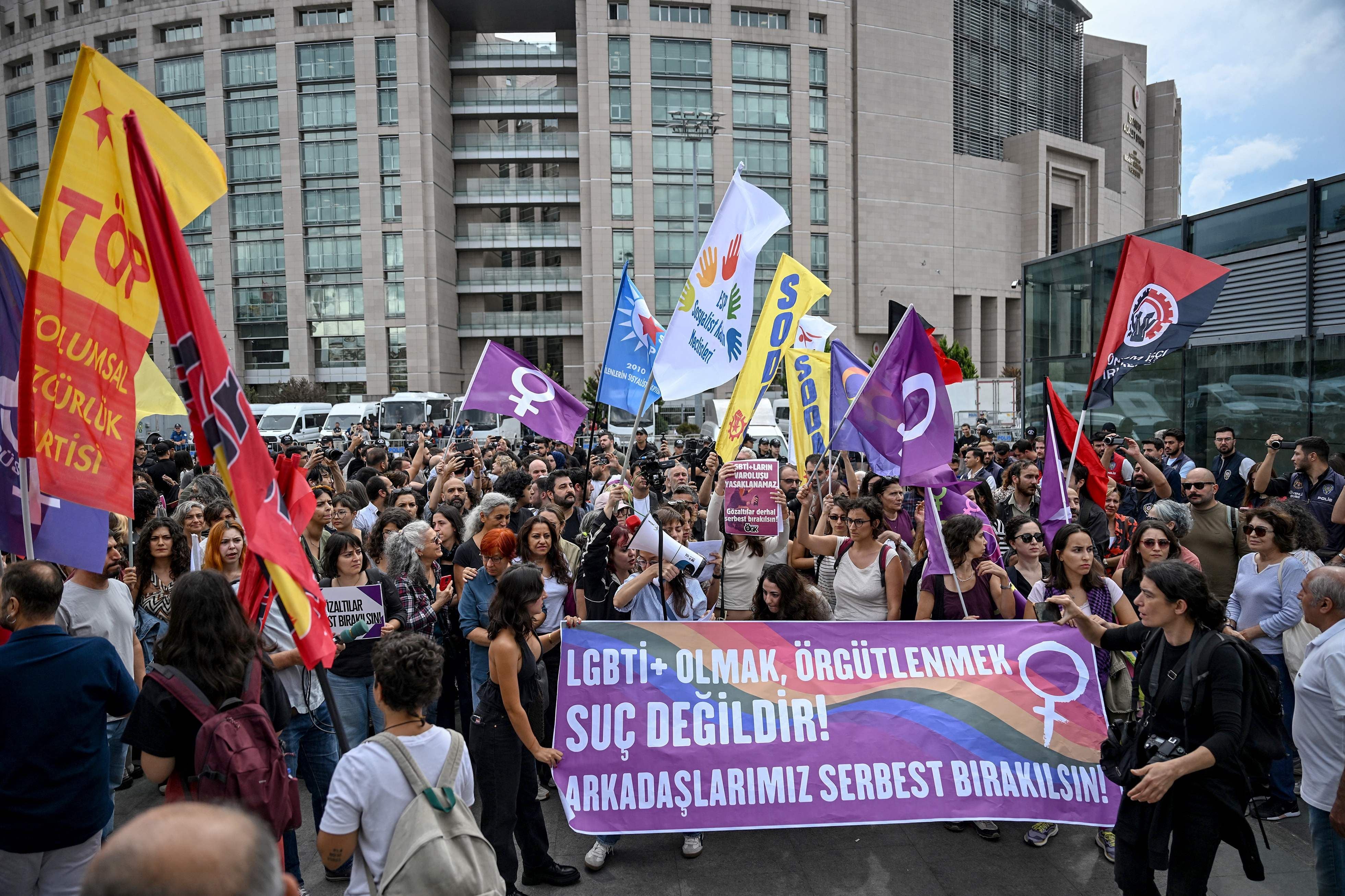 Demonstration vor Istanbuls Gerichtsgebäude mit LGBTQ+-Banner und vielen protestierenden Menschen.