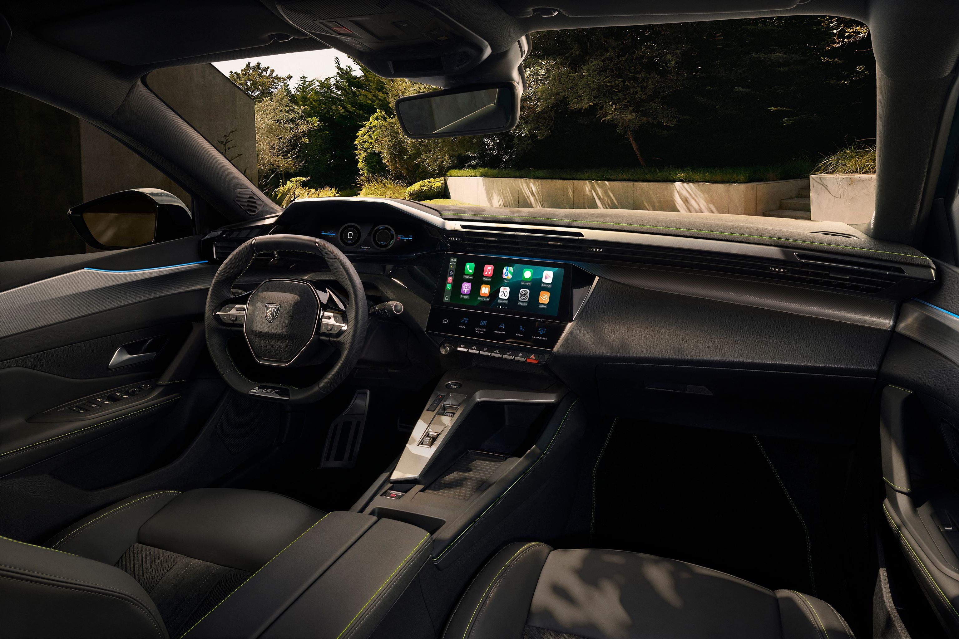 Modernes Auto-Cockpit mit großem Touchscreen, digitalem Tacho und sportlichem Lenkrad.