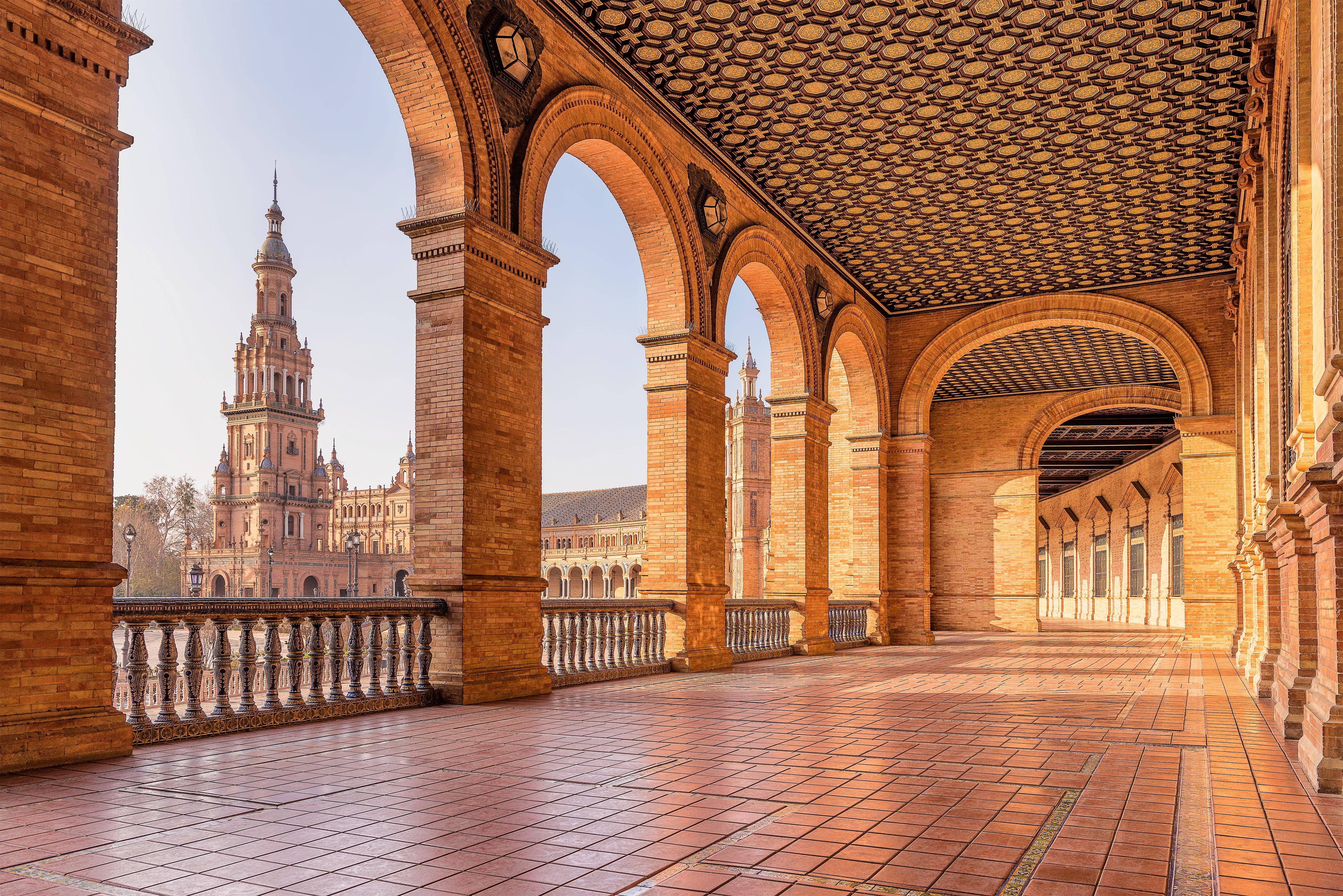 Blick auf den Plaza de España in Sevilla mit Arkaden und Türmen bei Tageslicht.